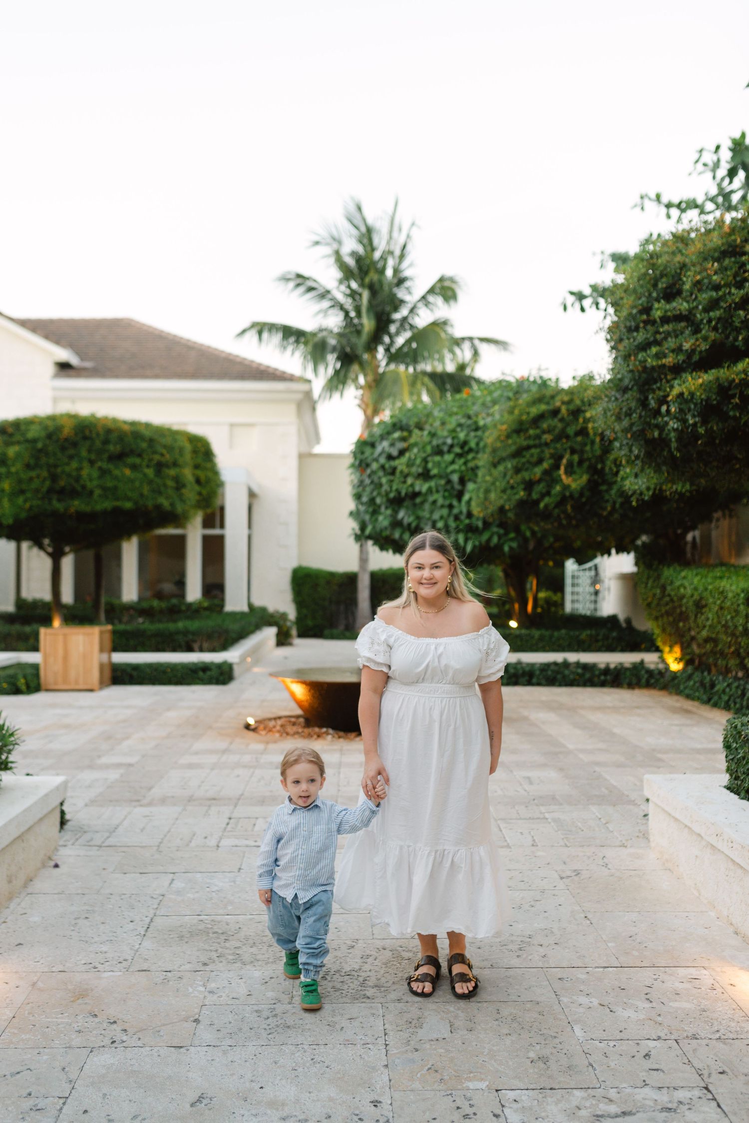 A scenic walkway with tropical landscaping and palm trees at an upscale property.