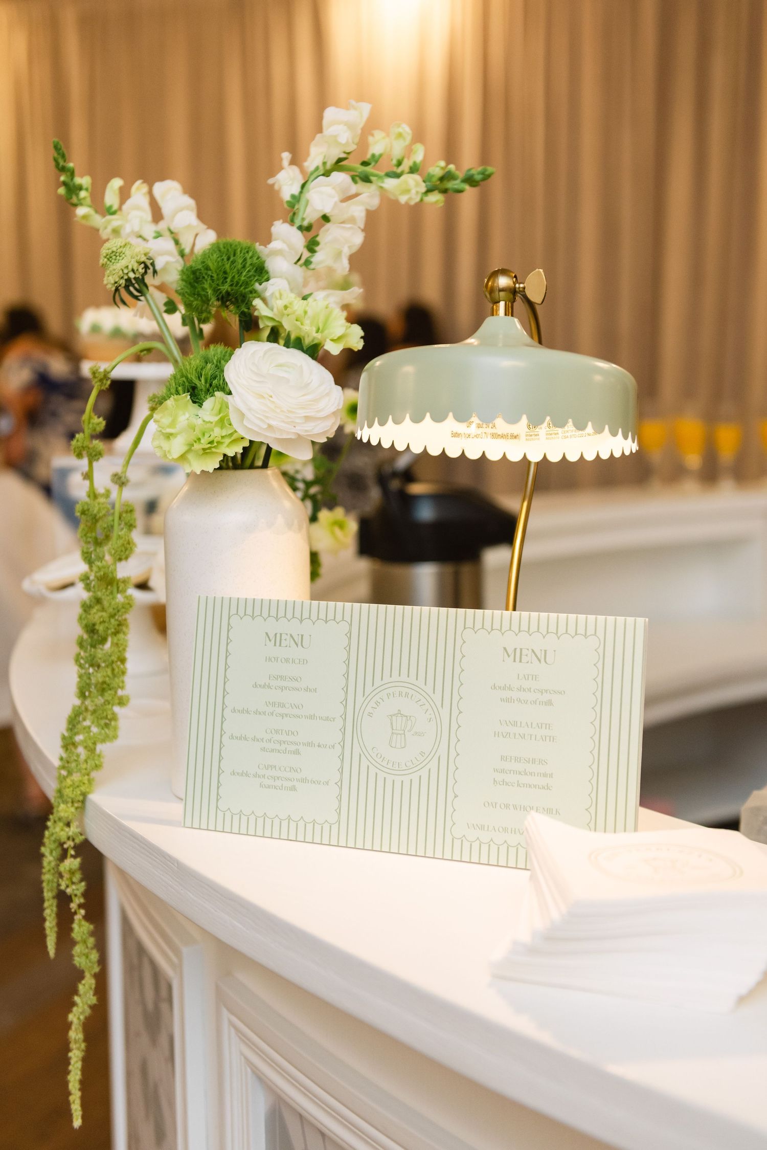 Elegant white menus and floral arrangements displayed on a table with soft lighting.