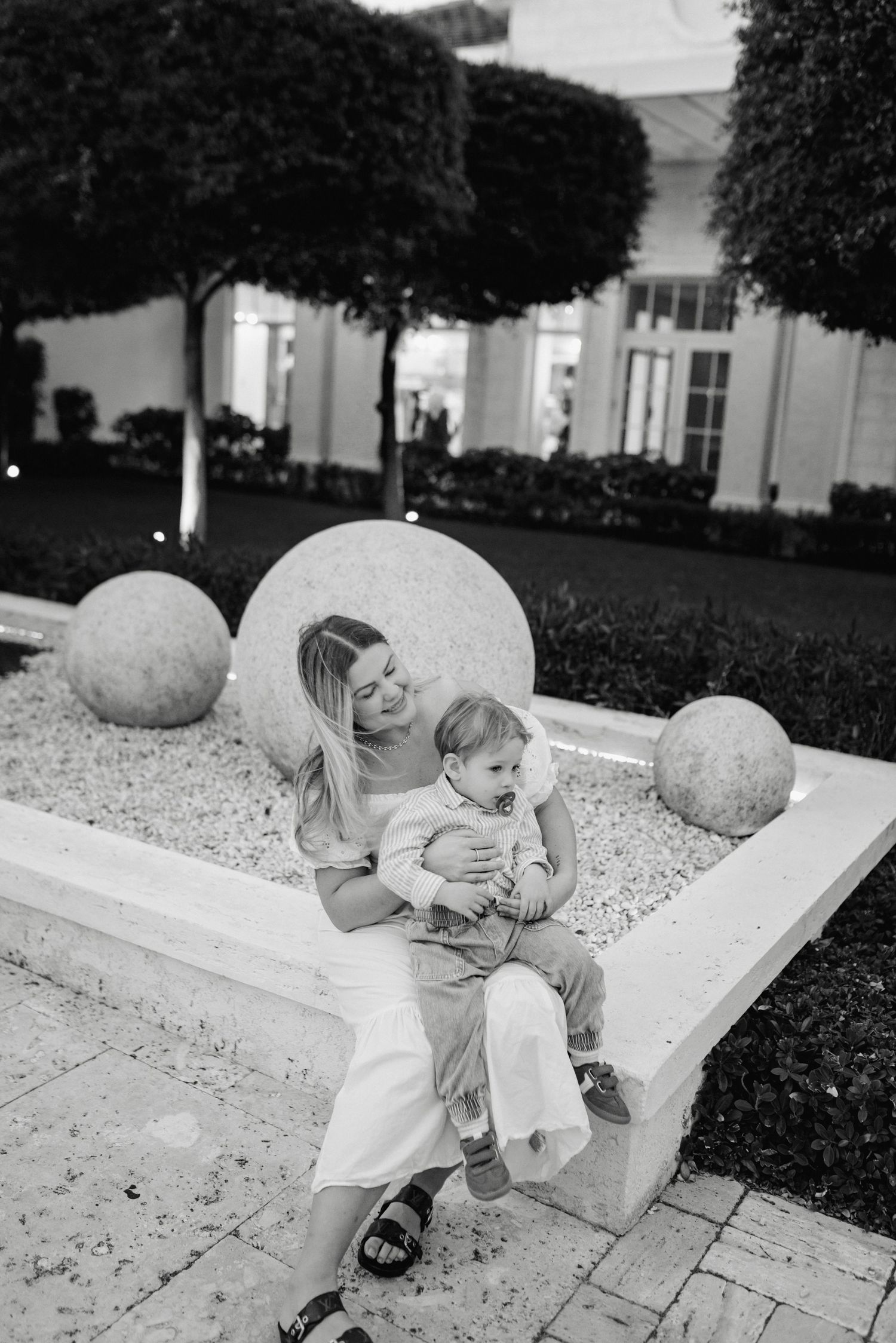 Black and white sequence of a child playing on a concrete ledge outdoors.