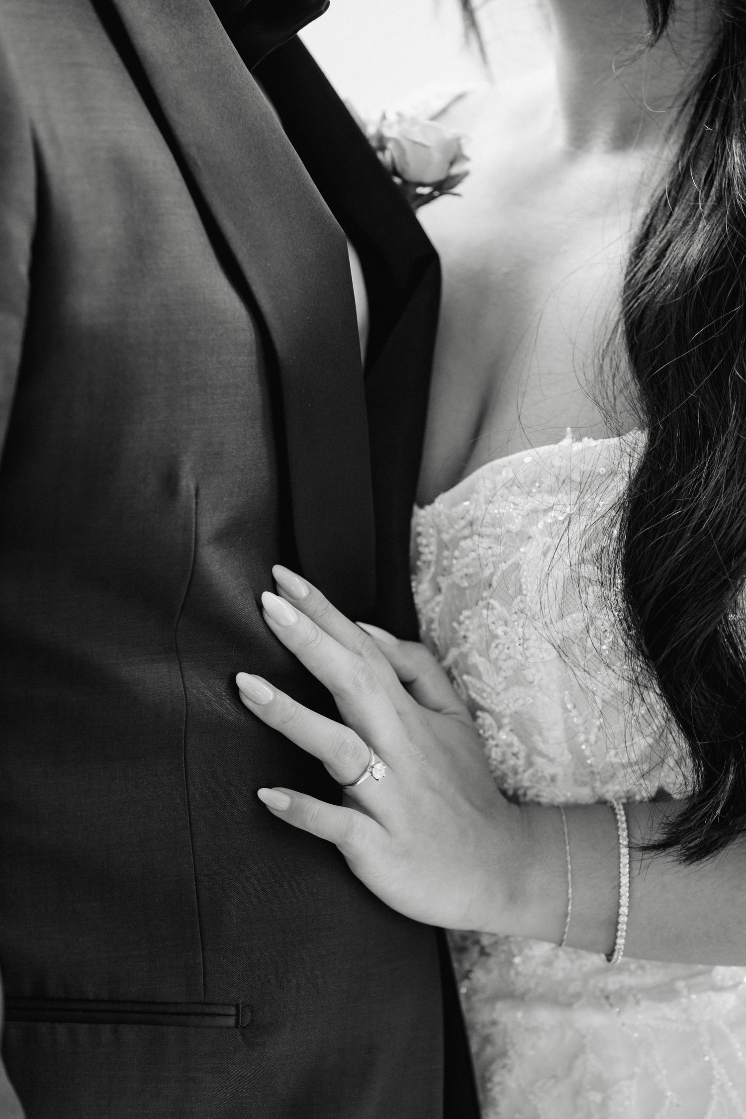 Black and white close-up details of bride and groom embracing.