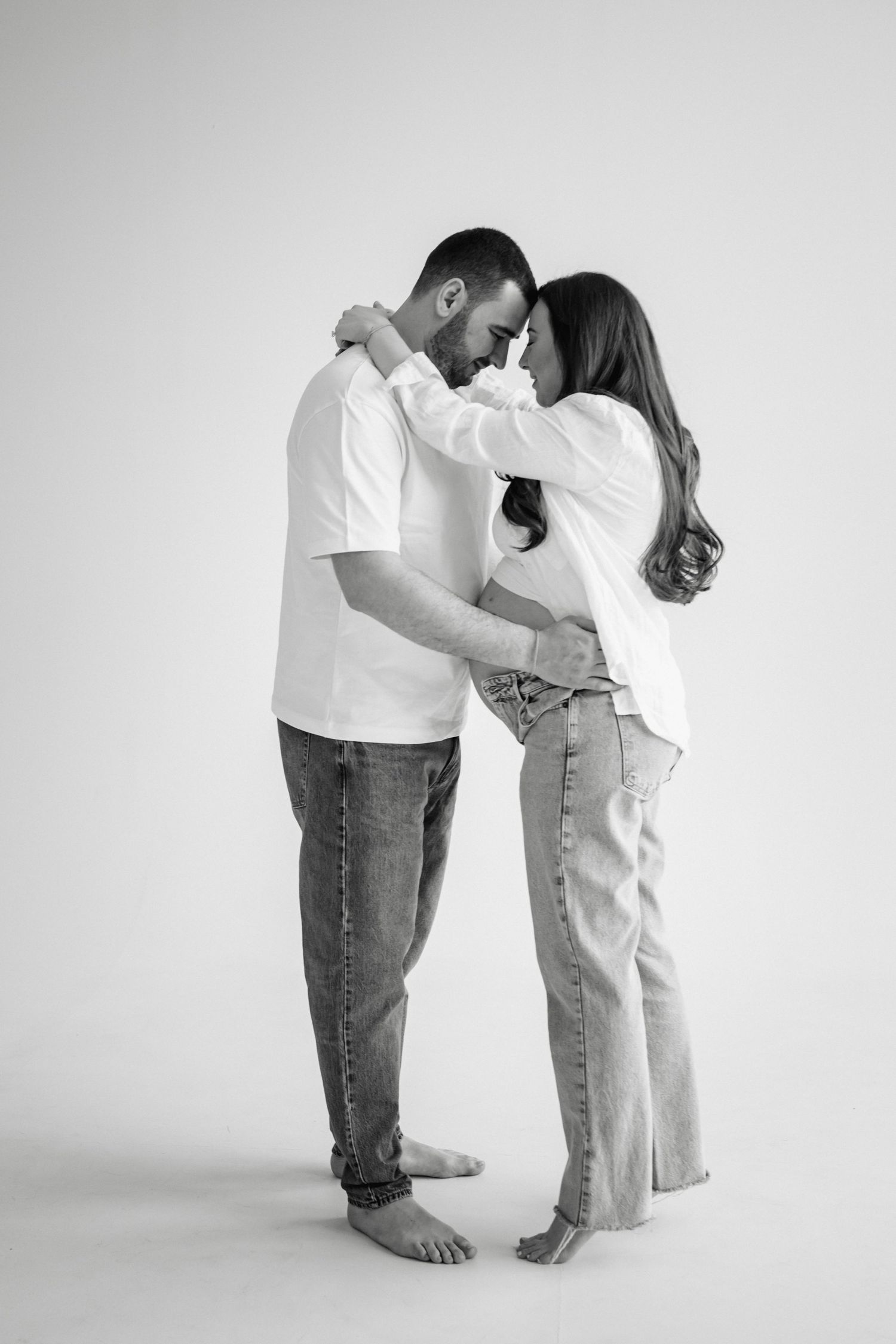 A black and white photo series showing a couple in casual clothes bowing towards each other in progressive stages.