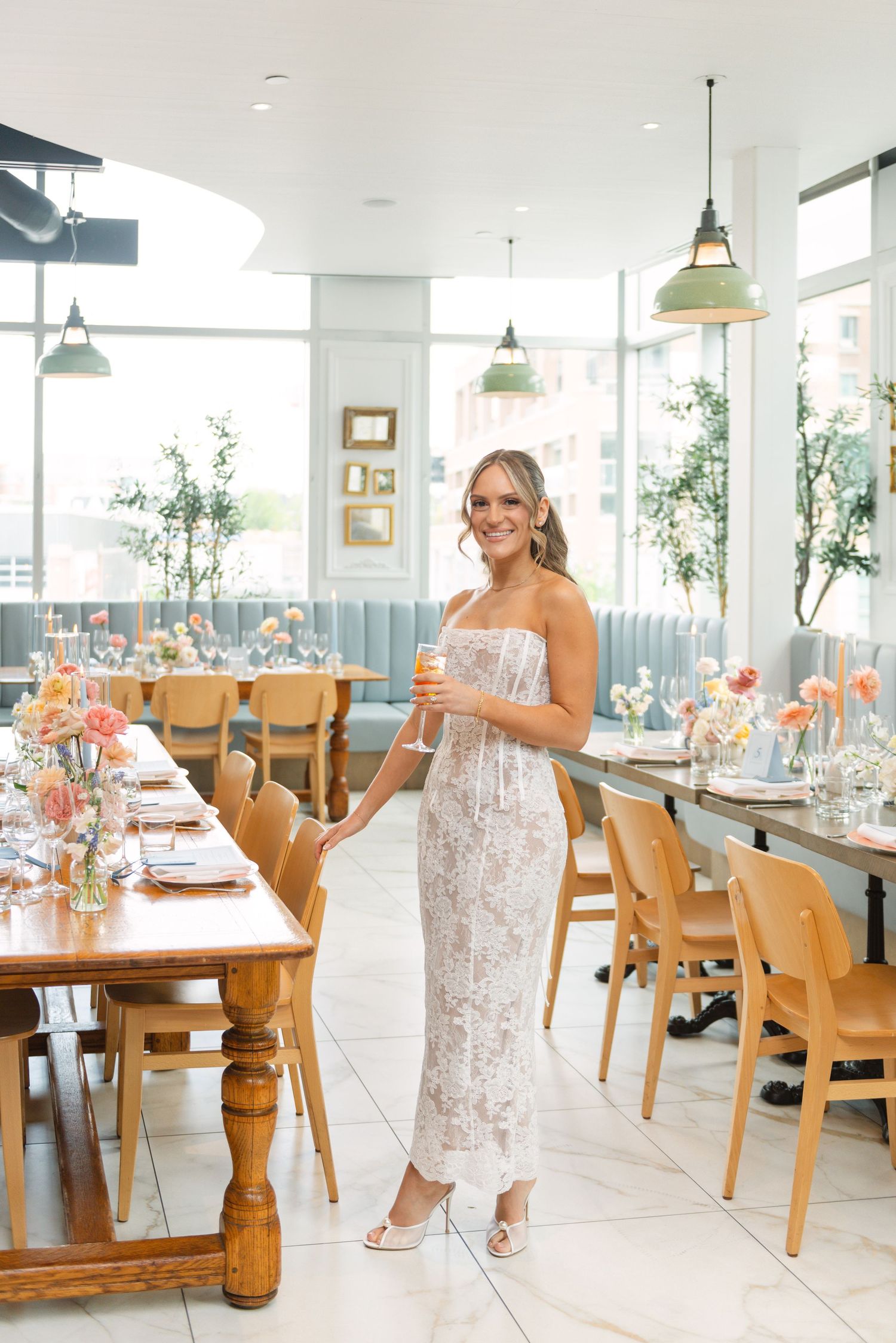 Elegant restaurant interior with wooden tables and blue upholstered seating decorated with peach floral arrangements.