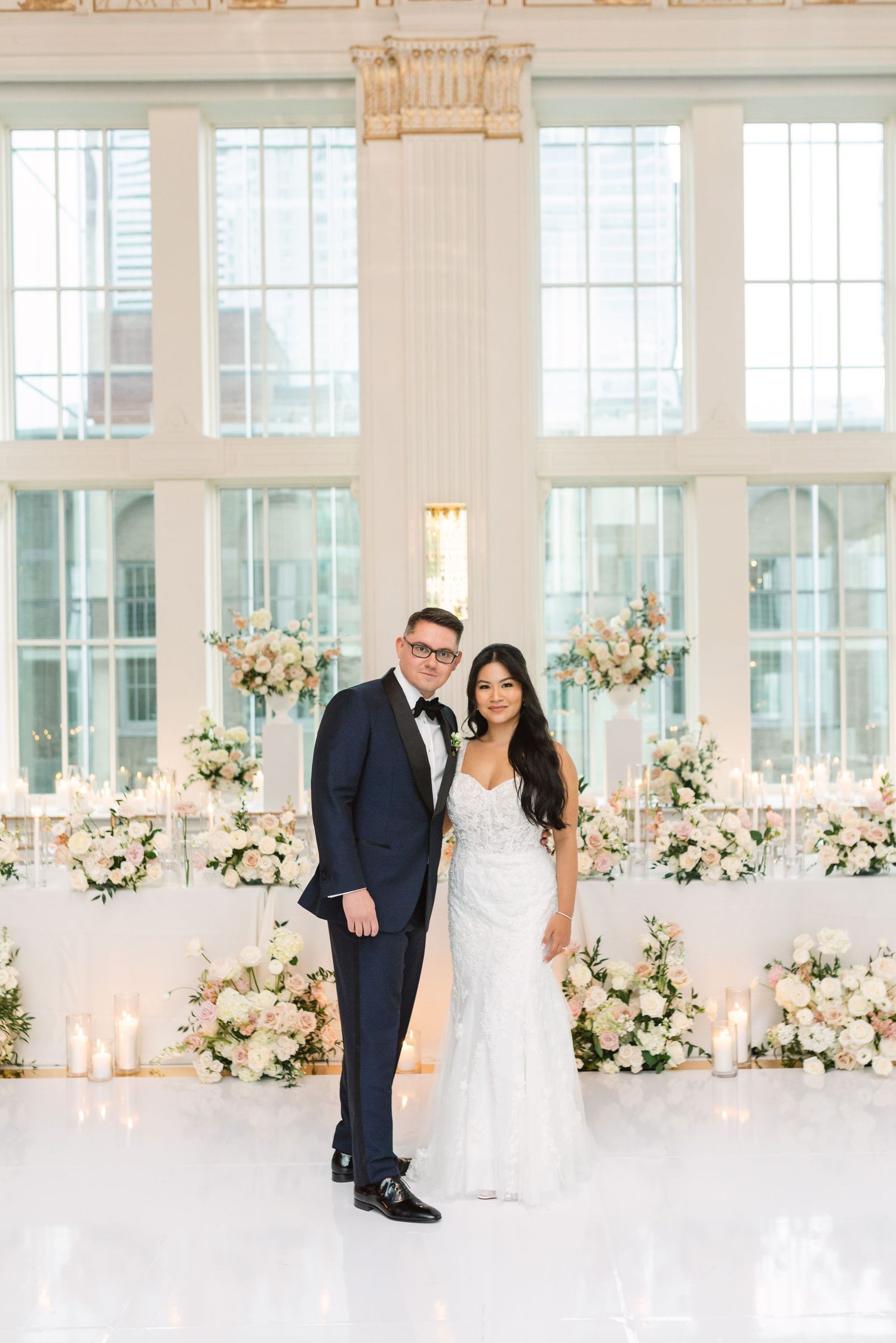 Elegant wedding venue with bright windows and floral decorations.