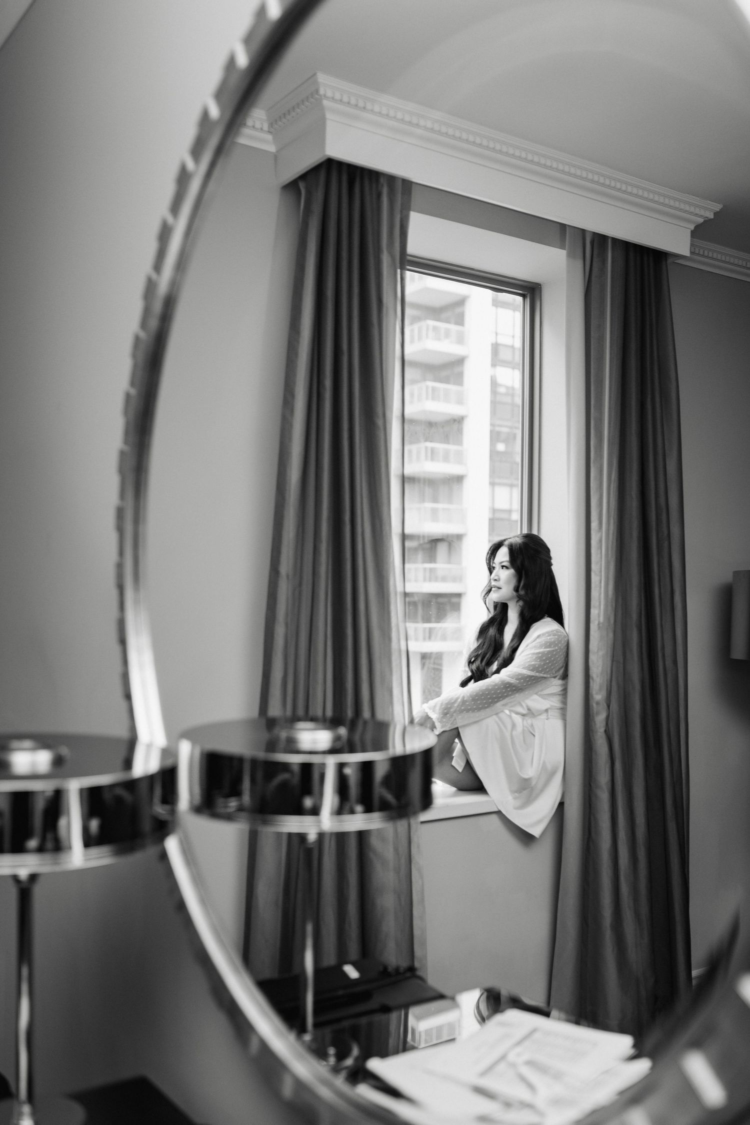 Black and white photos show a woman gazing out a window framed by dark curtains.