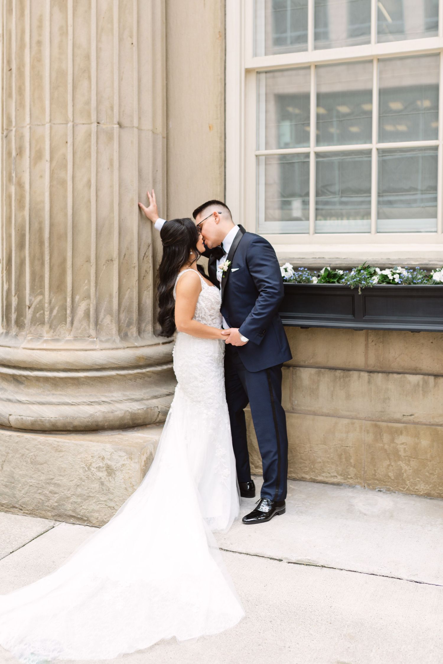 Sequence of romantic wedding poses against an elegant building facade with columns.