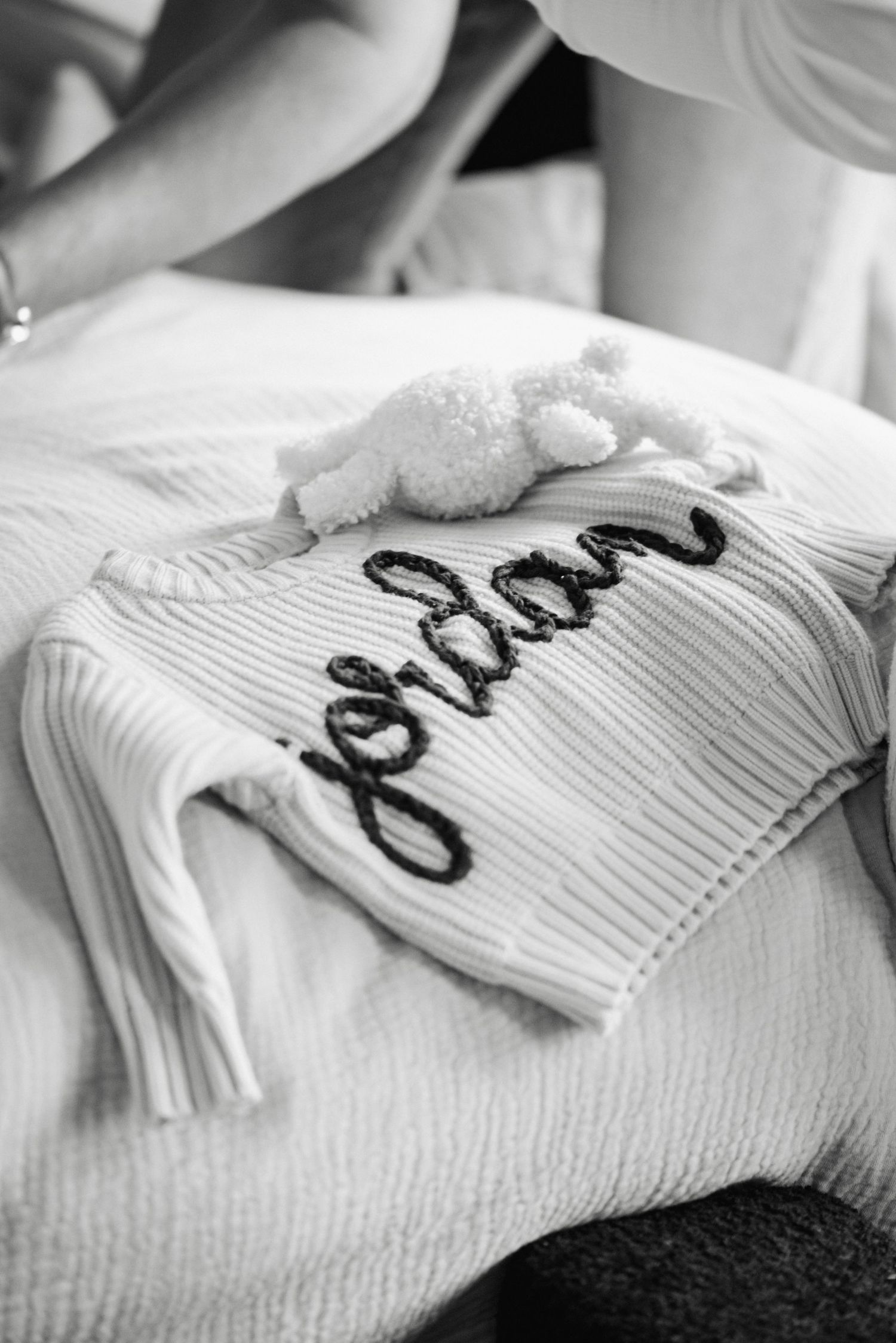 Black and white close-up sequence showing text being written in cursive on white textured fabric.