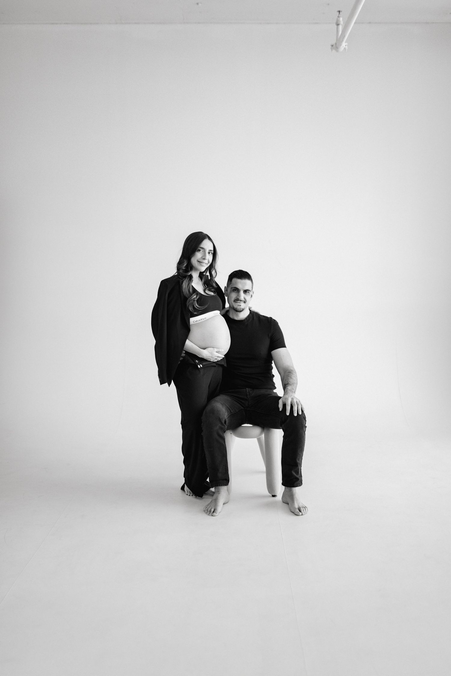 A minimalist black and white portrait series showing intimate poses against a white backdrop.