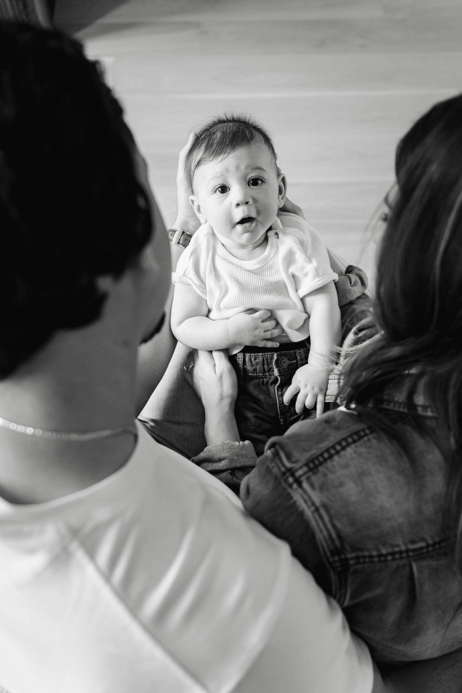A series of black and white photos showing a baby being held and fed from a bottle.