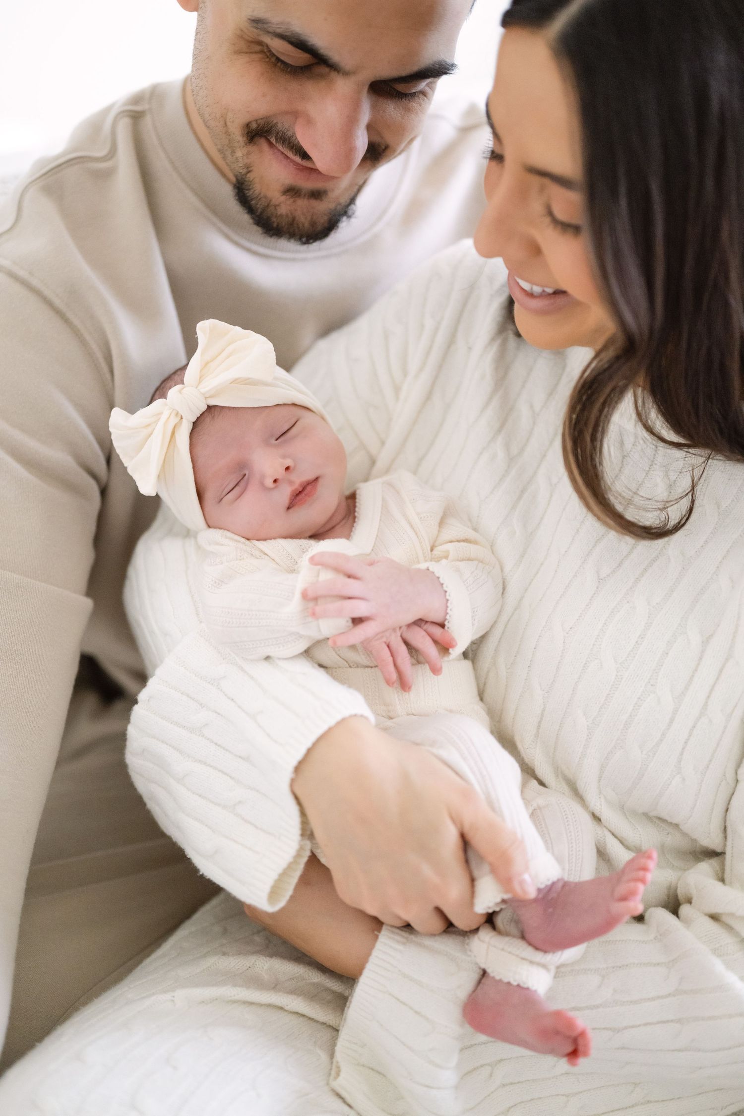 An intimate indoor family moment with soft white knit clothing.