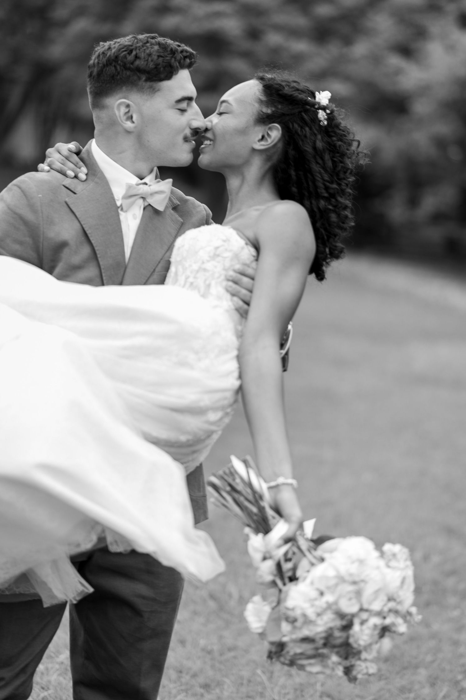 A romantic black and white wedding portrait captured outdoors.