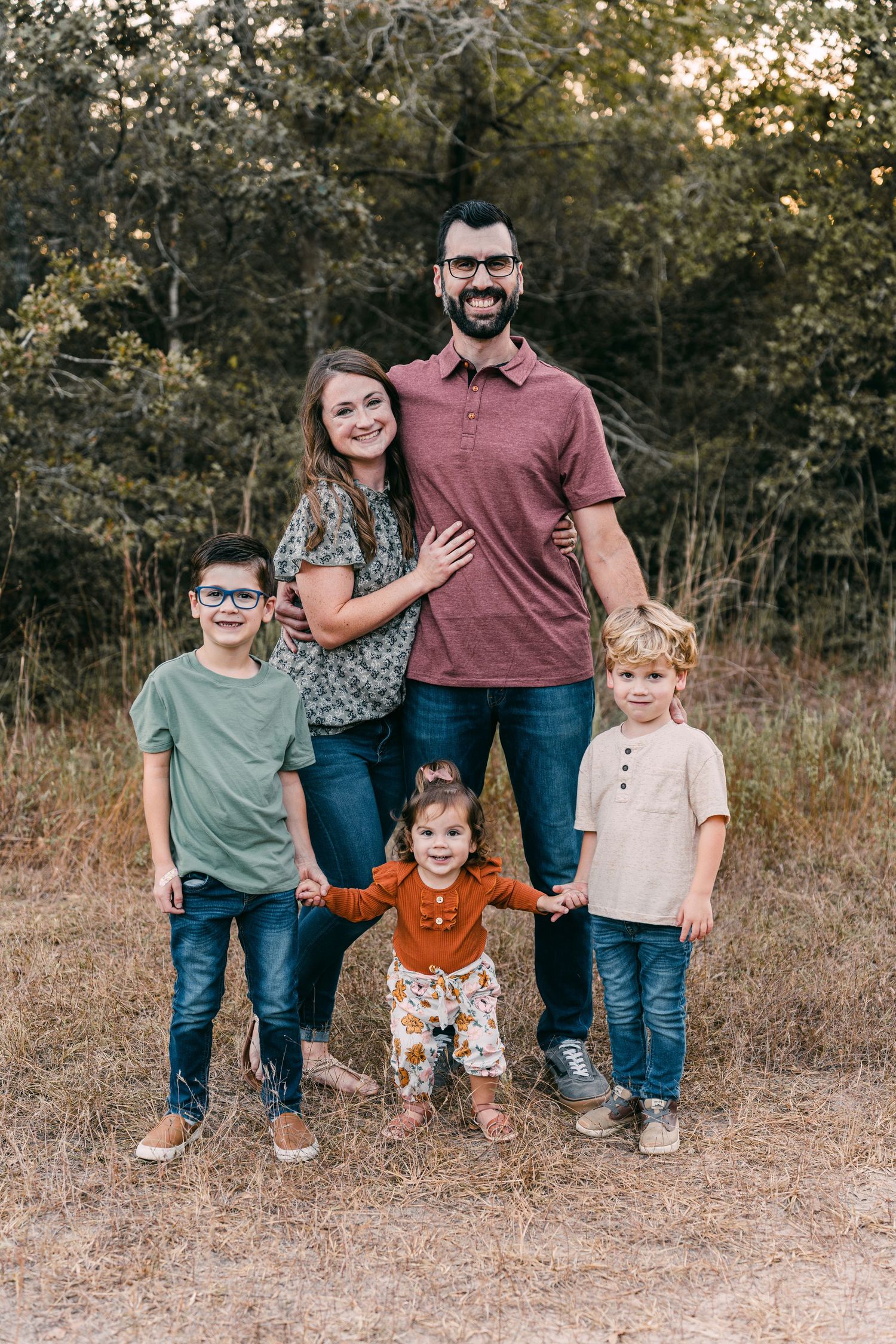 Natural light family portrait session in field with rustic autumn setting.