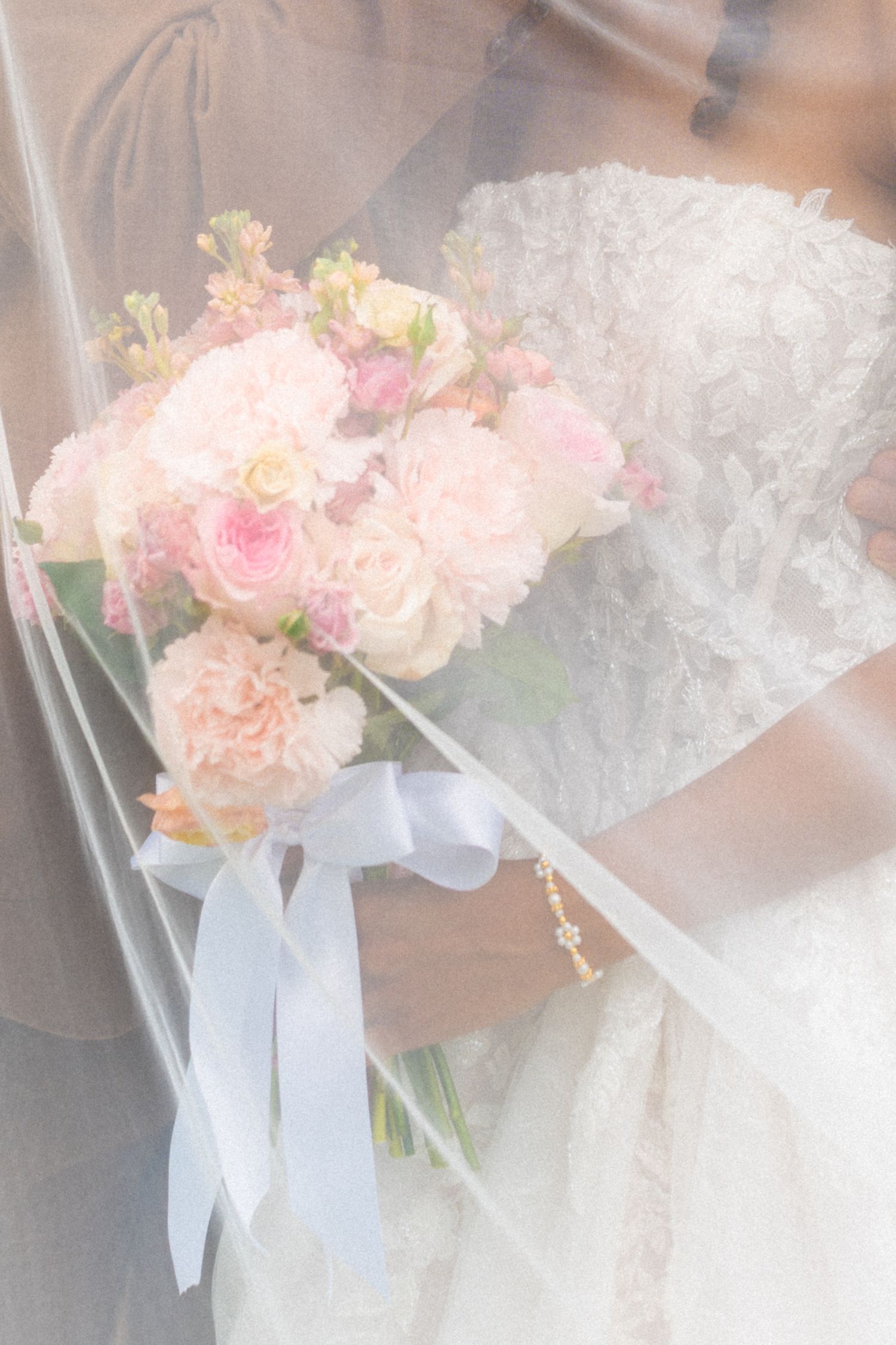 Delicate pink and white floral bouquets wrapped in white ribbon for a wedding celebration.
