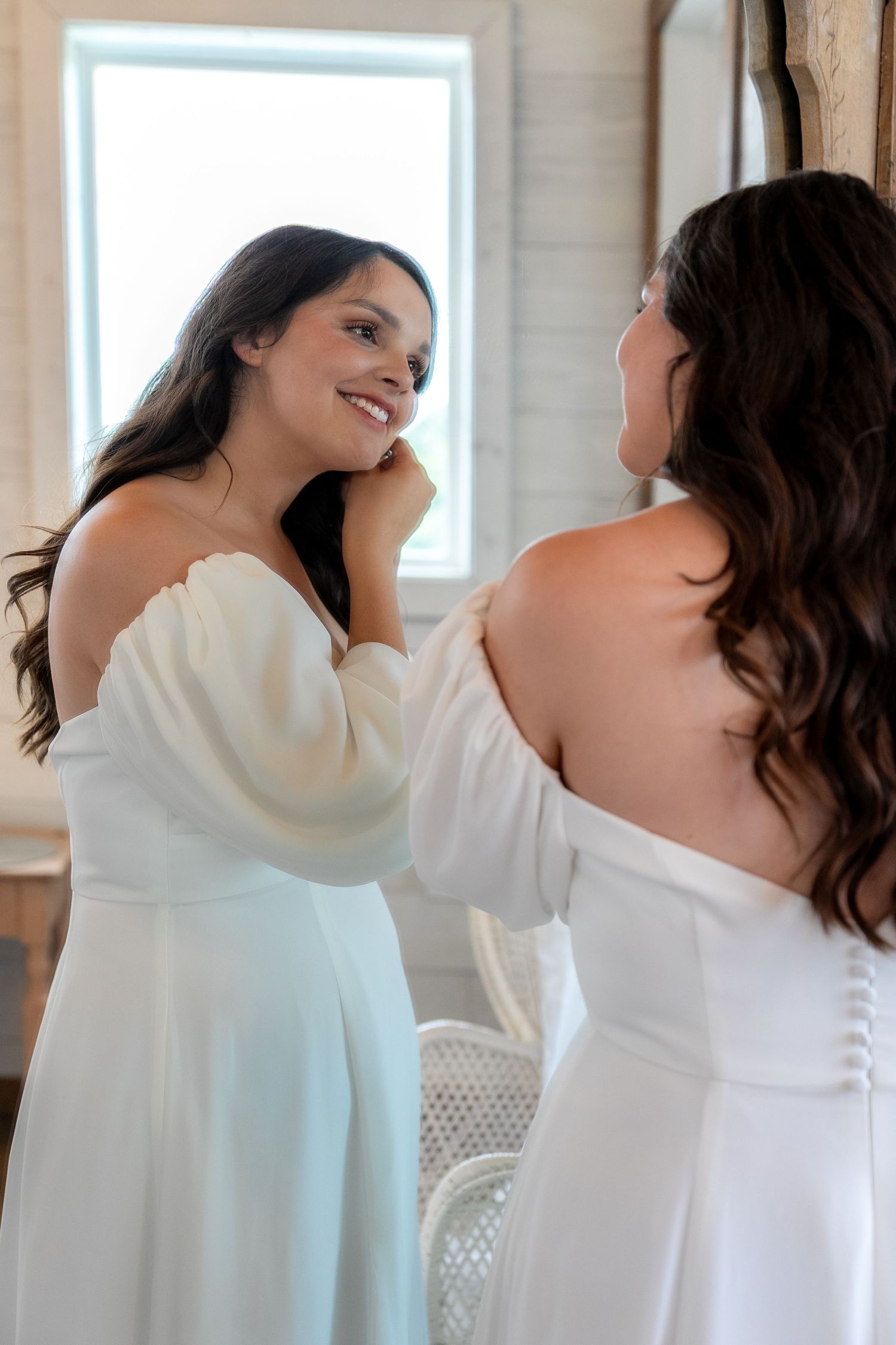 Elegant getting ready moments captured in a bright indoor setting with white decor.