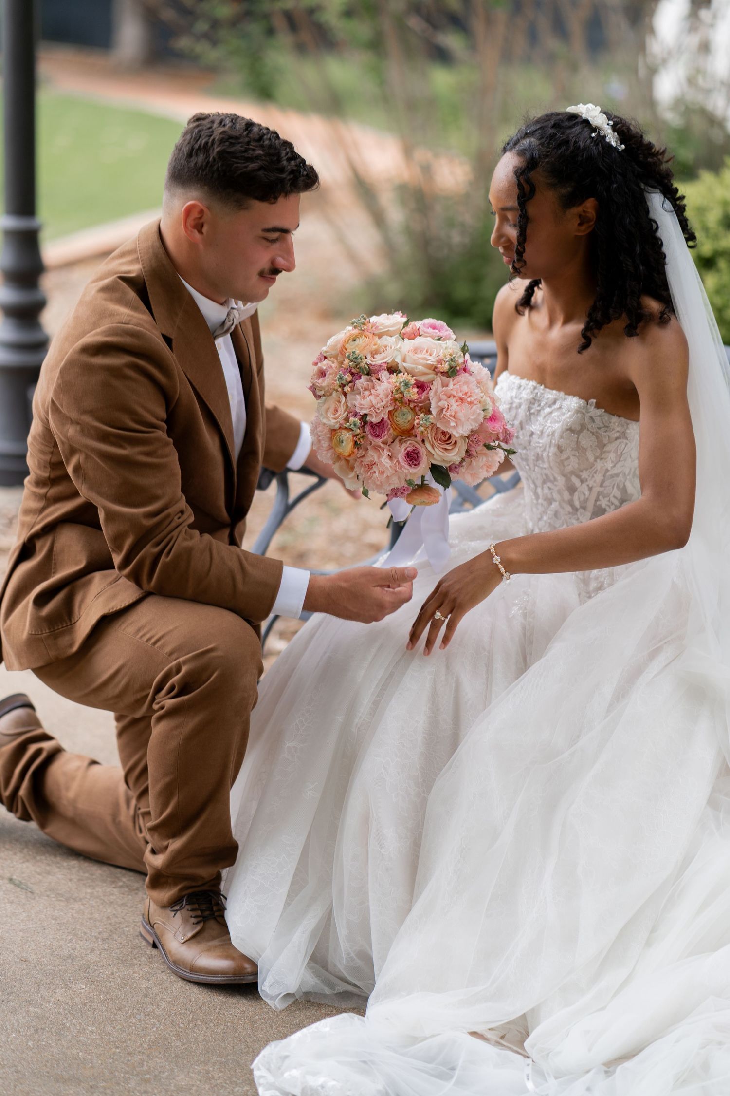 A romantic wedding photo session outdoors featuring brown suit and white dress details.