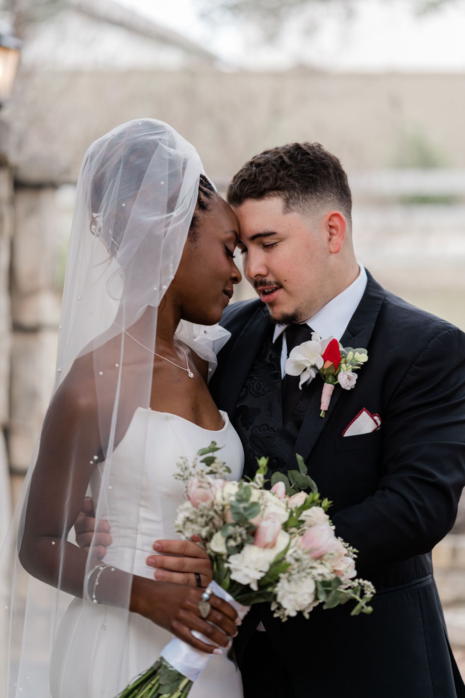 A romantic wedding couple shares intimate moments in a series of tender poses with white and pink floral bouquets.
