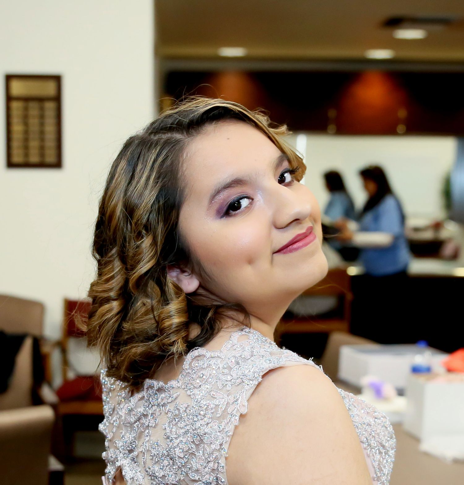 A quince in a light pink dress poses playfully in a photo showing excitement during her photography session, San Antonio St Anthony de Padua