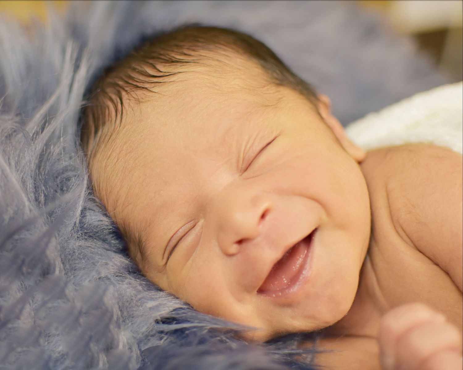 a newborn baby's changing expressions and movements while sleeping, smiling. San Antonio newborn photography