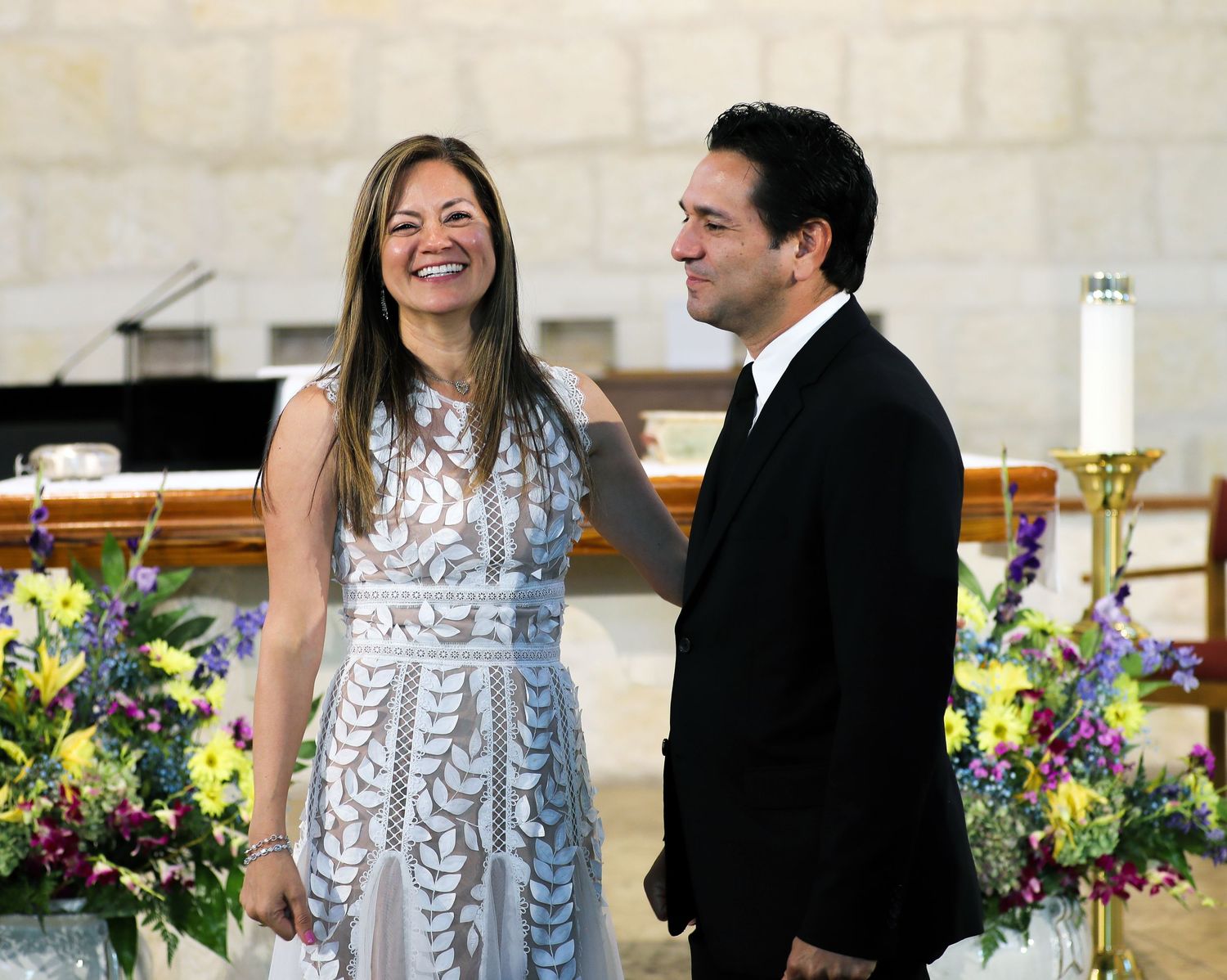 Wedding reception scene with couple in formal attire and floral decorations. San Antonio wedding photography