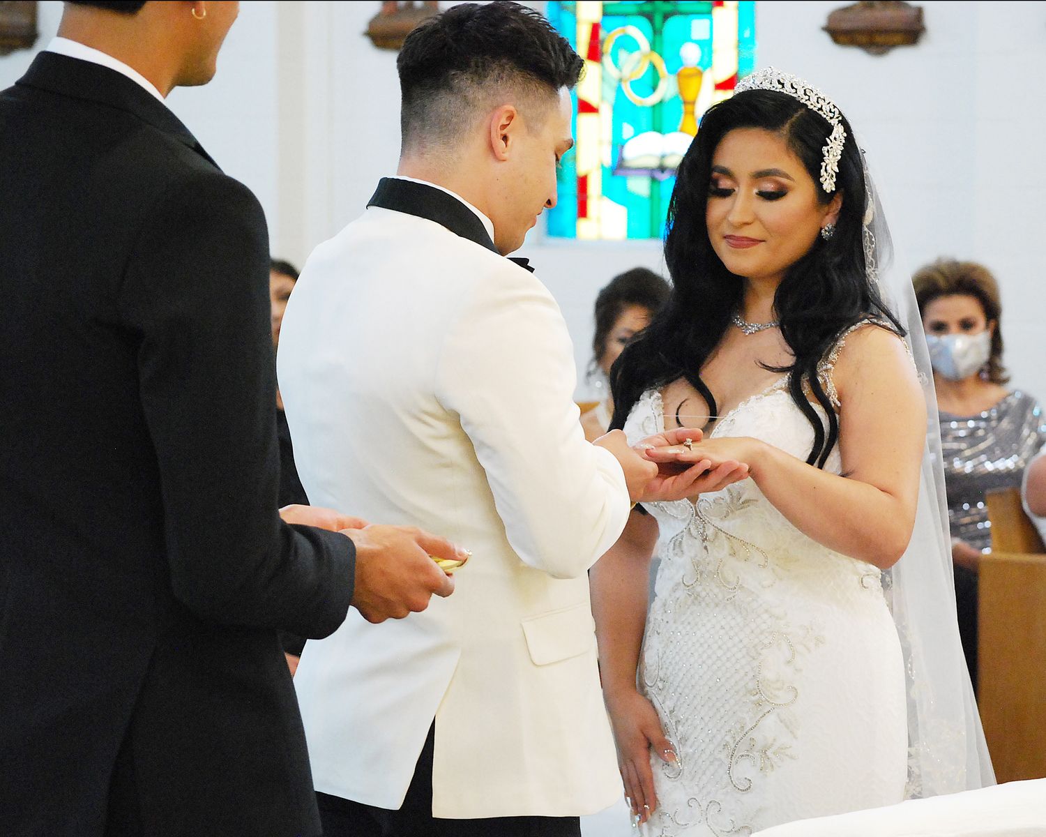 Wedding couple sharing an intimate rings moment during their ceremony in a church setting. San Antonio wedding photography