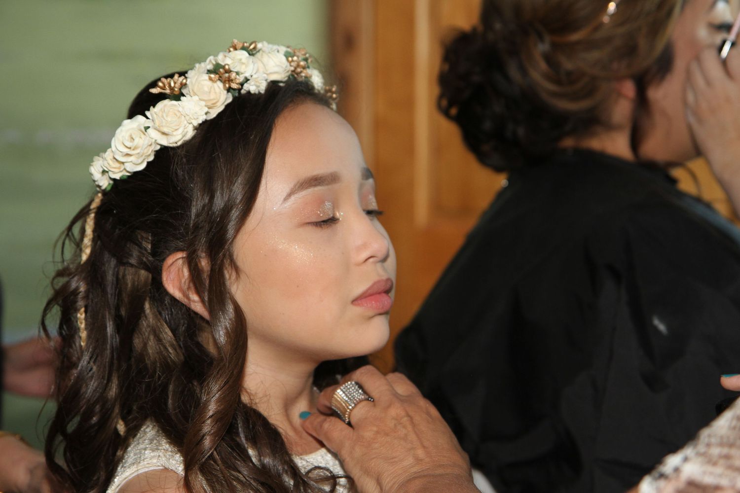 Close-up shots of bridal party hair and makeup preparation with floral crown details. San Antonio wedding photography