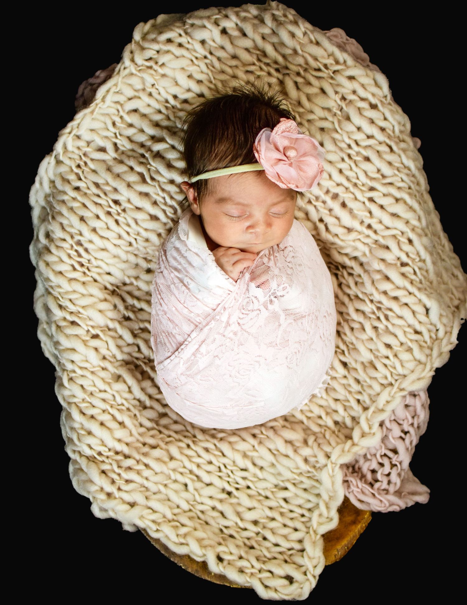 Newborn sleeping in cream knitted nest on black background, San Antonio newborn photography