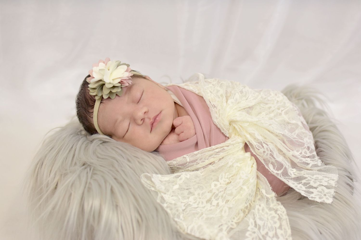 Baby sleeping peacefully on cream lace fabric, San Antonio newborn photography session