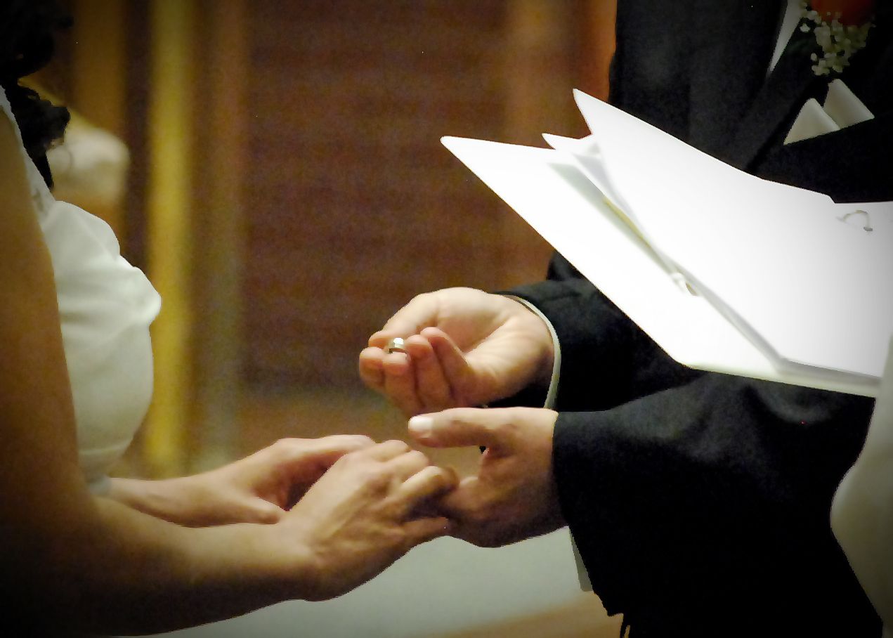 Close-up of hands exchanging wedding rings during a ceremony. San Antonio wedding photography and Texas area