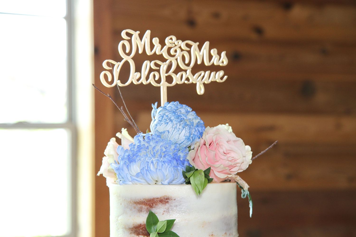 Wedding cake decorated with blue and pink flowers and a custom Mr & Mrs topper. San Antonio wedding photography Texas area