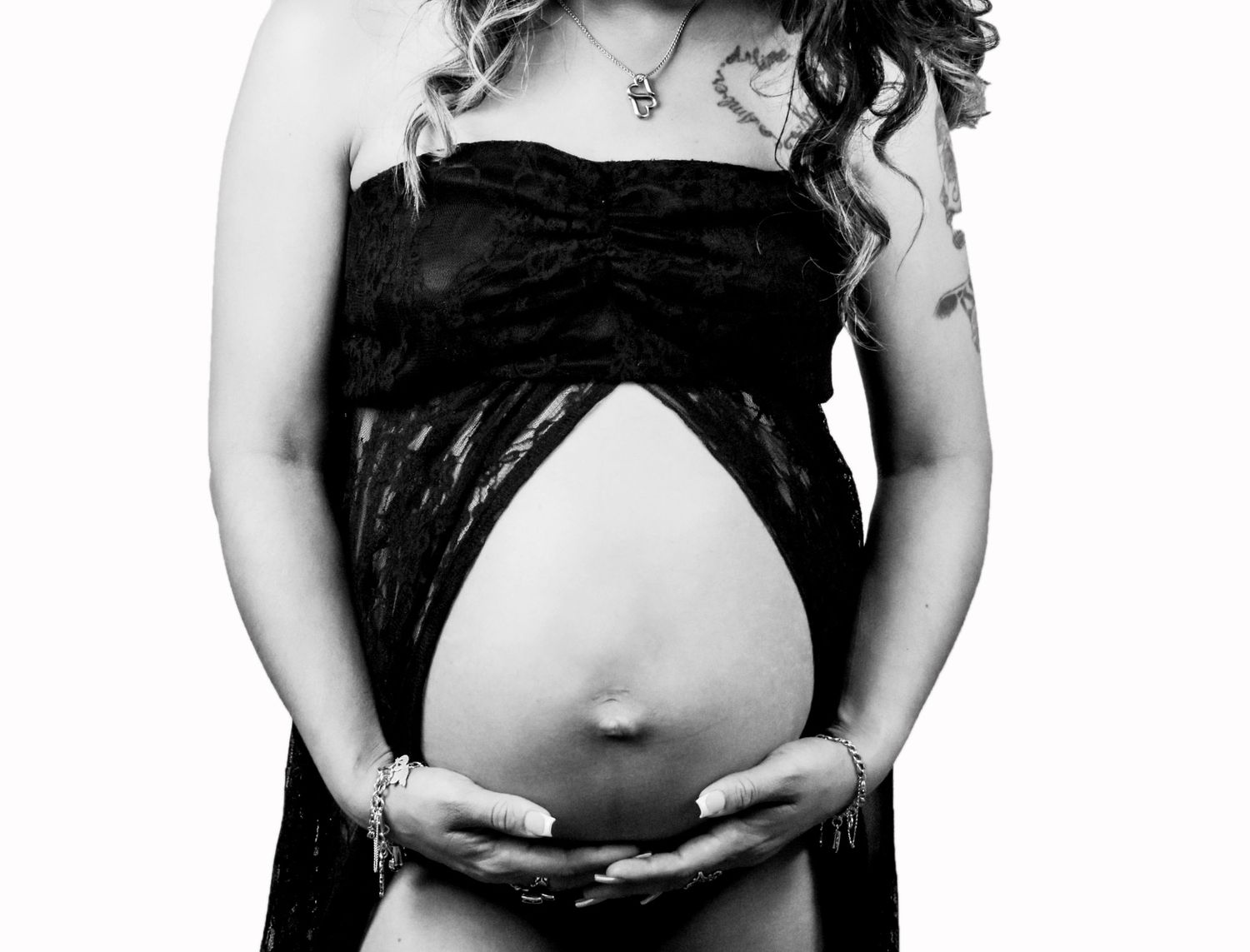A black and white maternity photo showing a pregnant belly in an artistic pose in San Antonio.