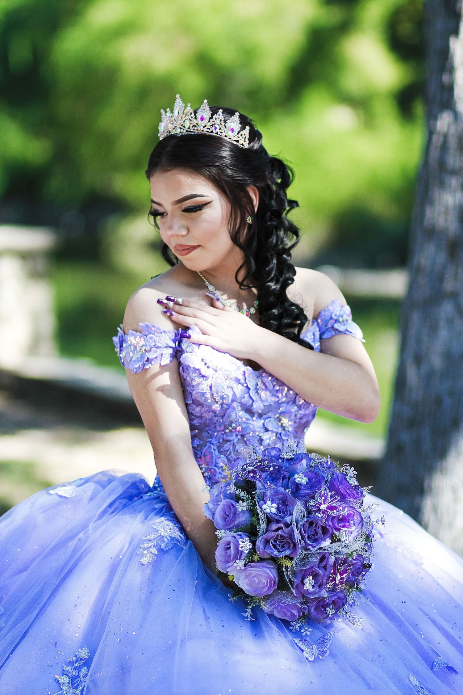 A dreamy purple themed sweet 16 photoshoot featuring an elegant ballgown and matching floral bouquet in San Antonio Riverwalk.
