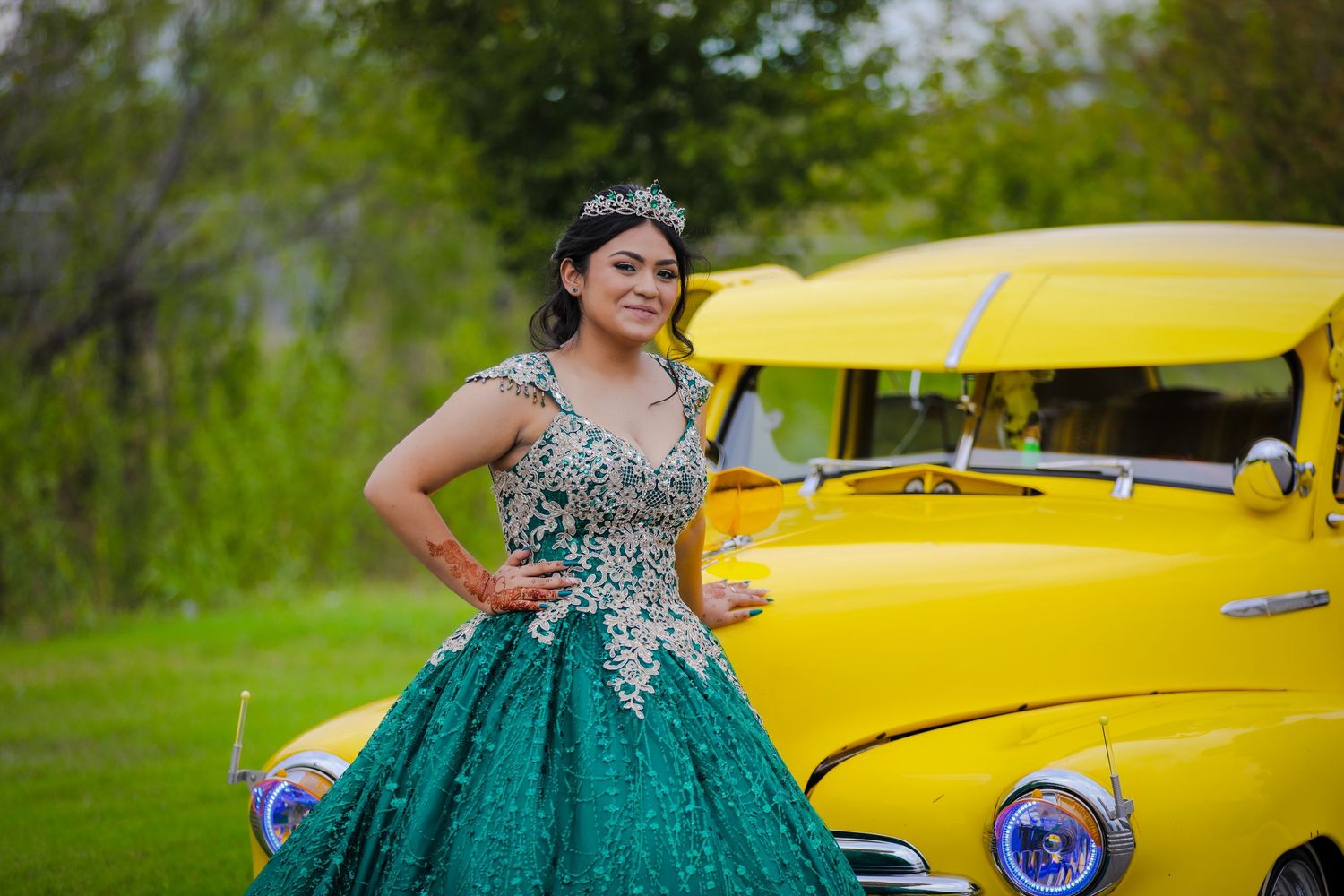 A bright yellow classic car serves as a backdrop for a sweet 16 photo session in South San Antonio, Texas.