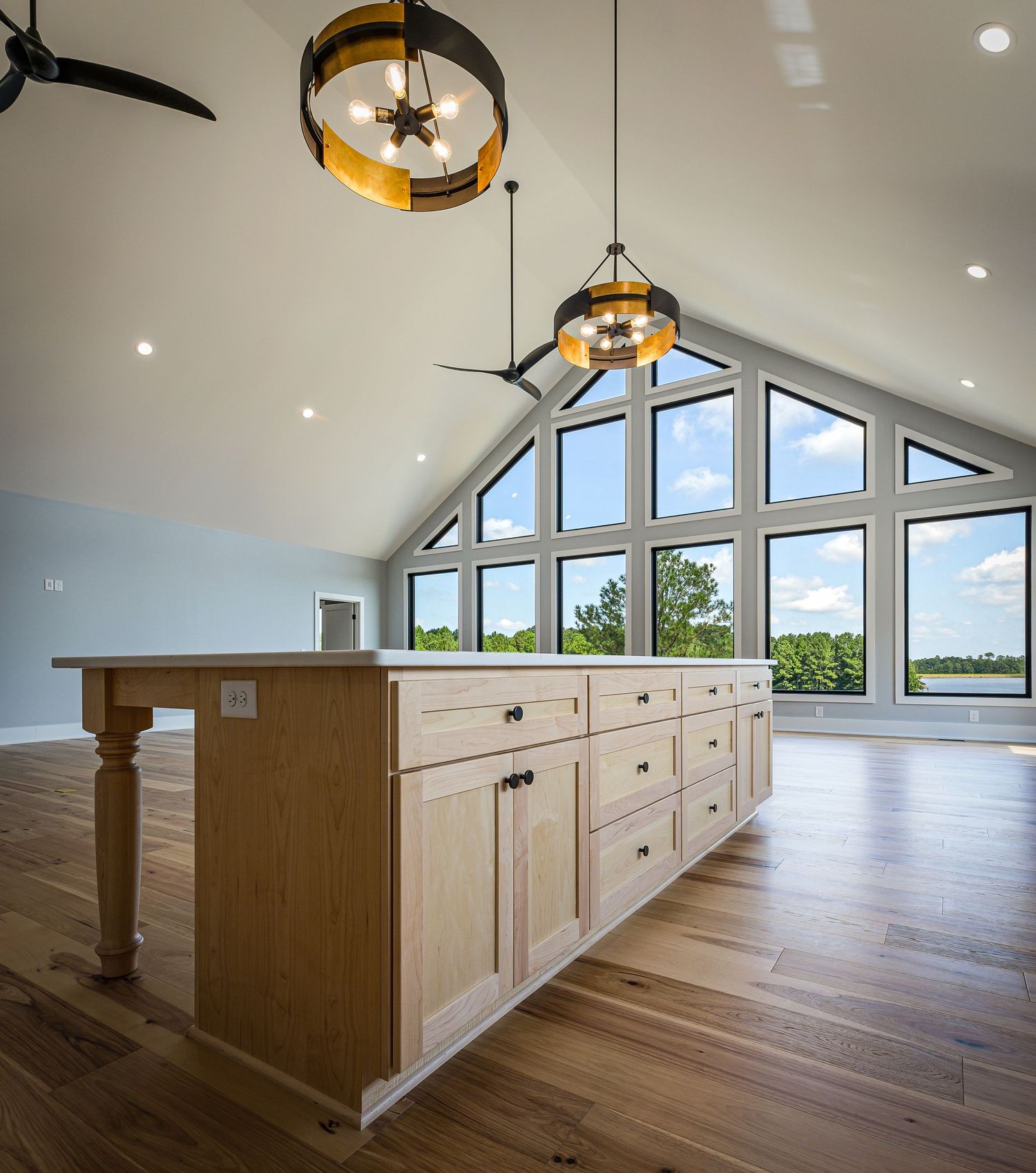 Bright open-concept living room in a Pinehurst home with hardwood floors and large windows. High-end residential kitchen photography.