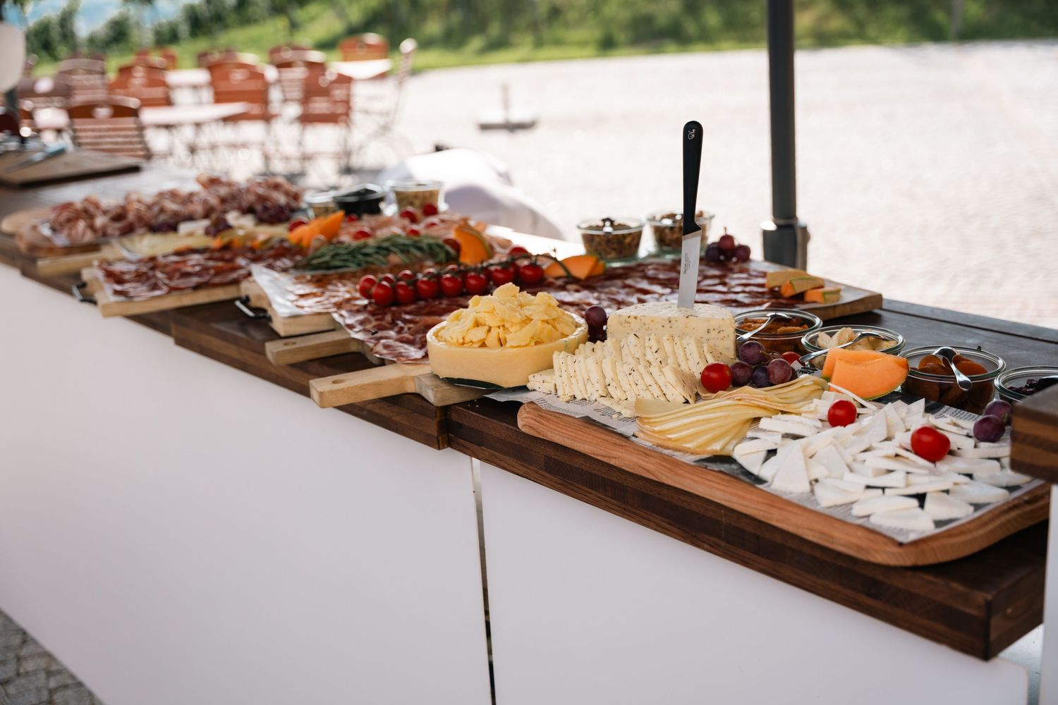 Beautiful outdoor wedding charcuterie and cheese grazing table display by the water.