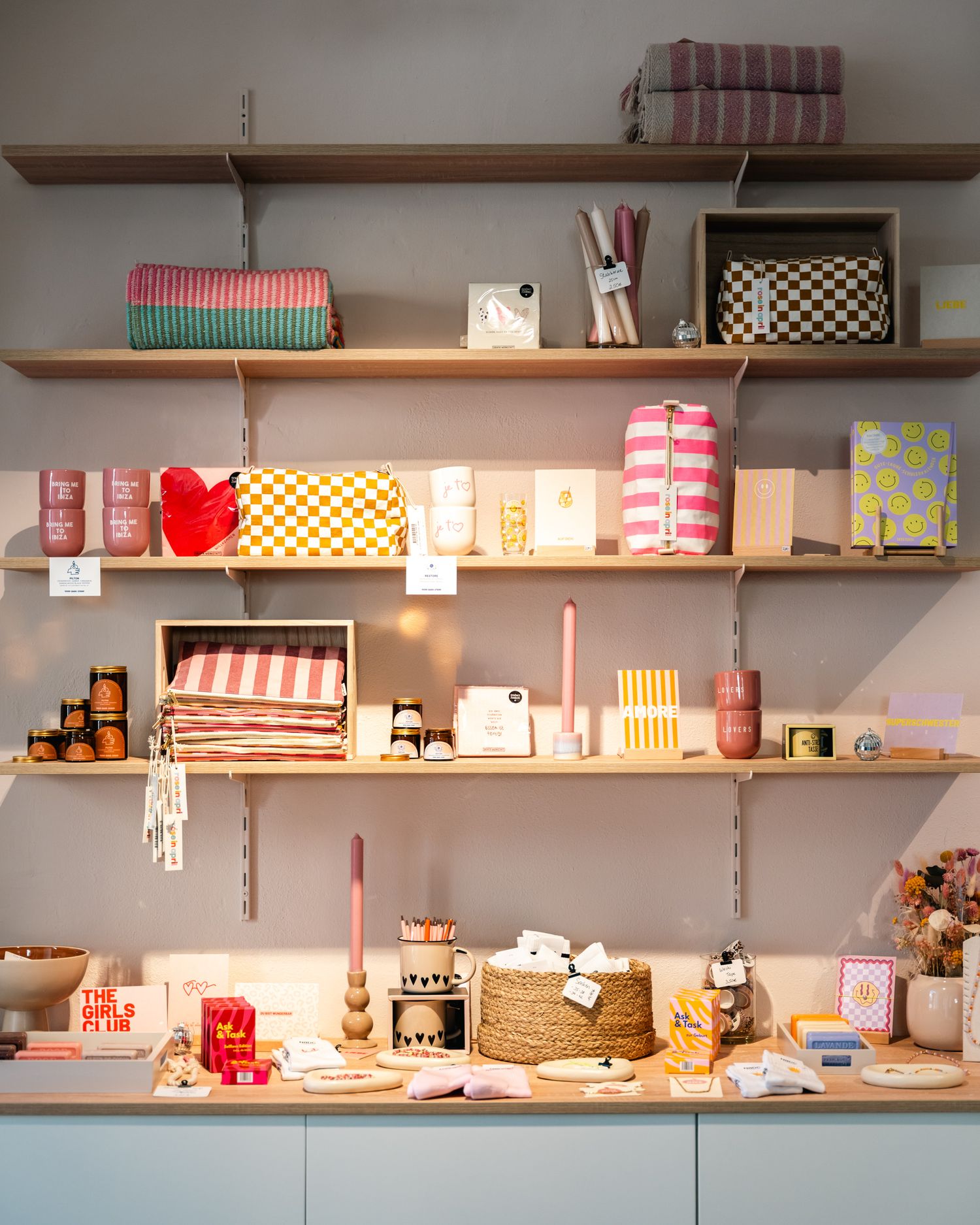 Colorful retail store shelves displaying neatly arranged gift items, textiles, and decorative products.