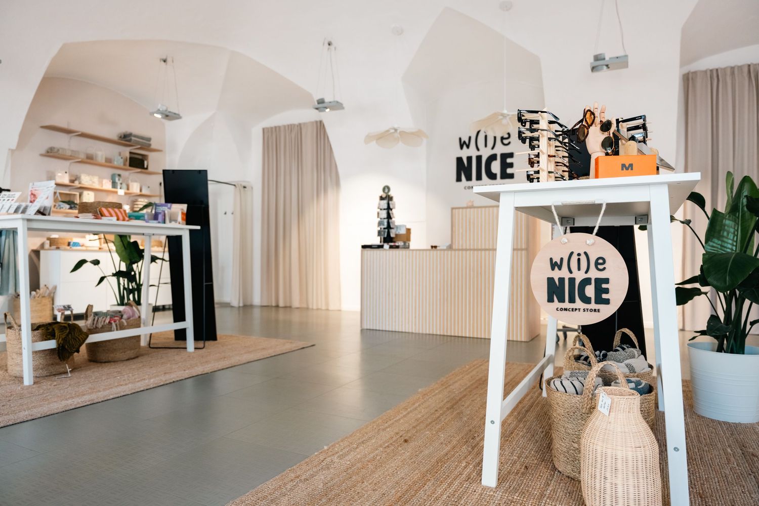 Bright boutique interior with white walls featuring w(i)e NICE branding.