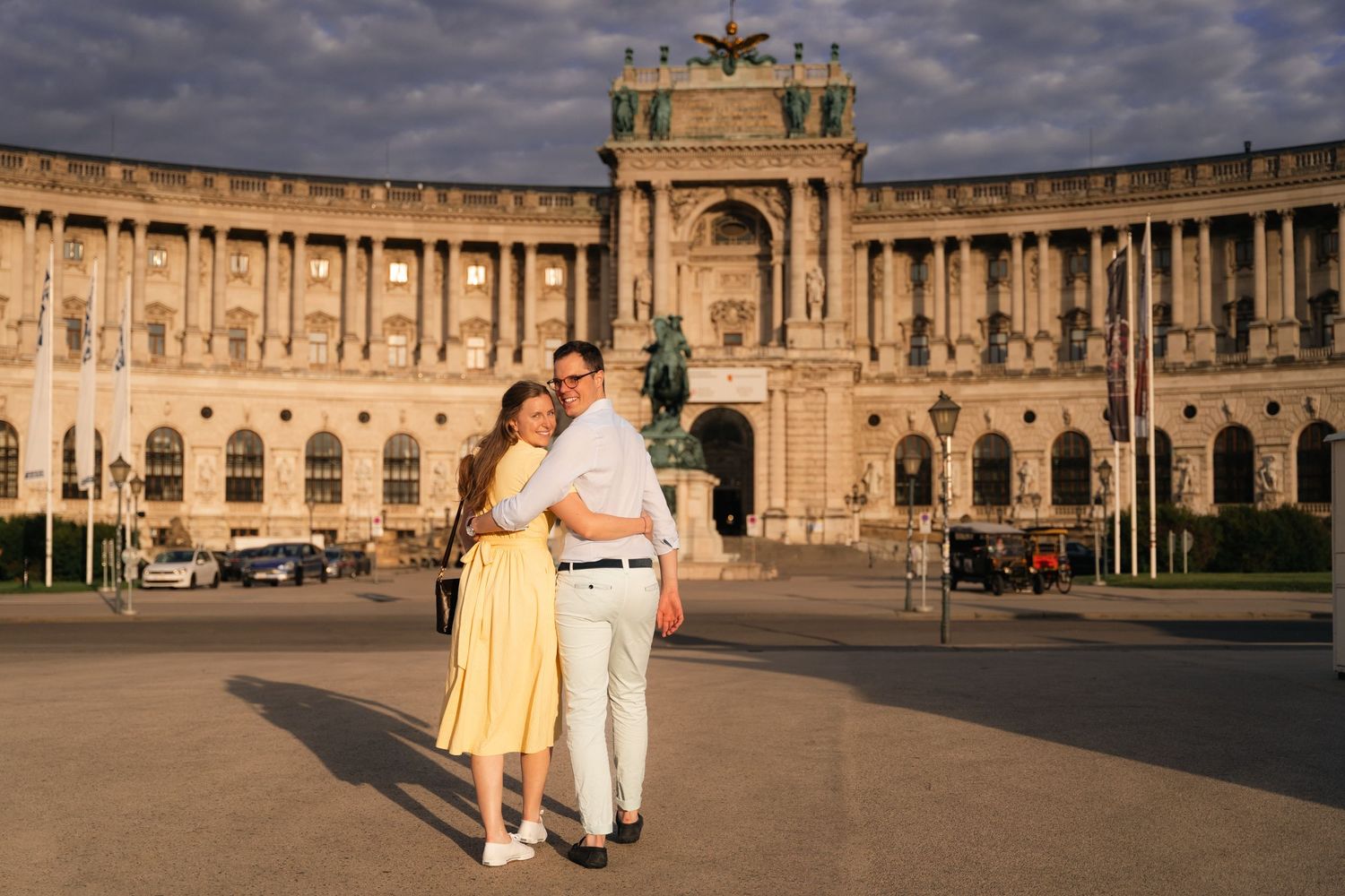 Couple embracing at golden hour in front of the majestic Hofburg Palace in Vienna, Austria.