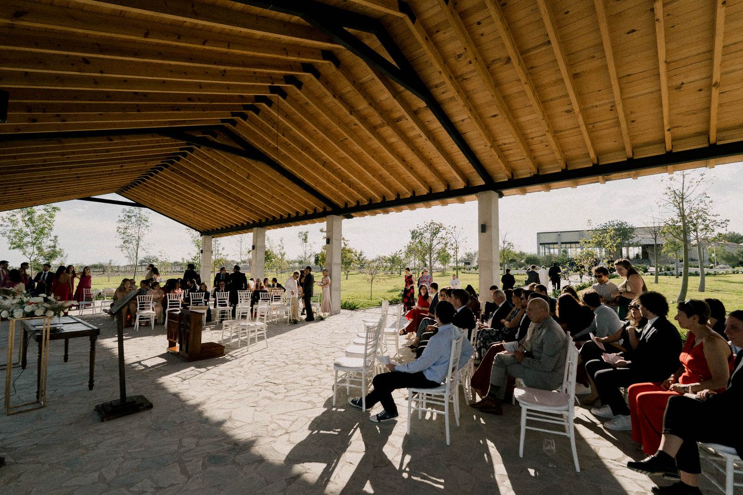 Outdoor wedding ceremony venue with wooden beams and mountain views in the background.