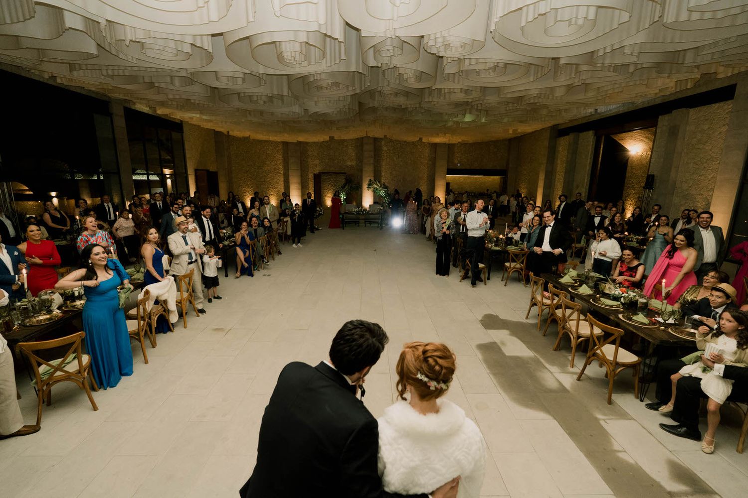 Wedding reception dance floor moment captured in panoramic view with guests watching.