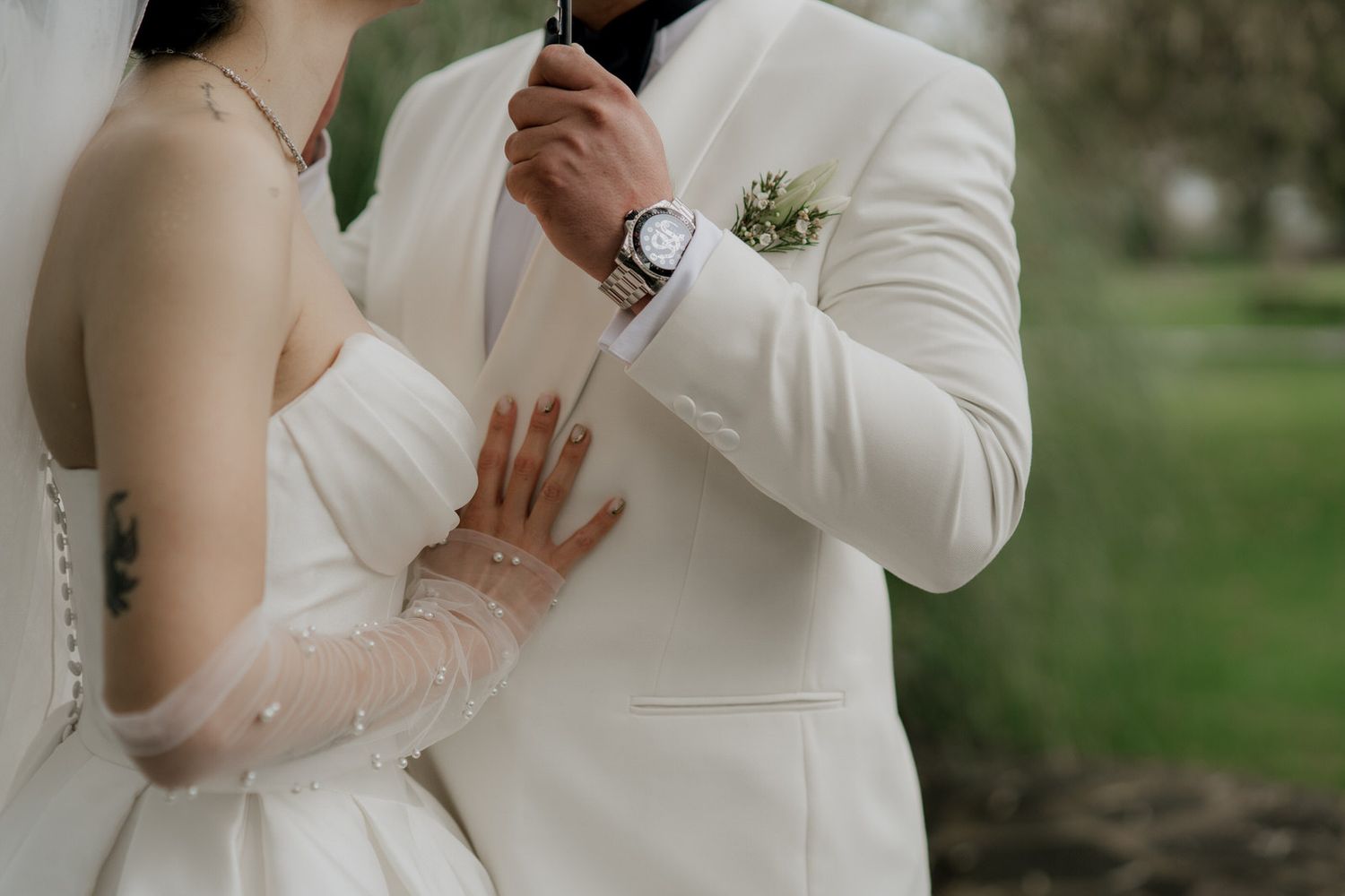 Elegant wedding couple shares tender moments in an outdoor garden setting.