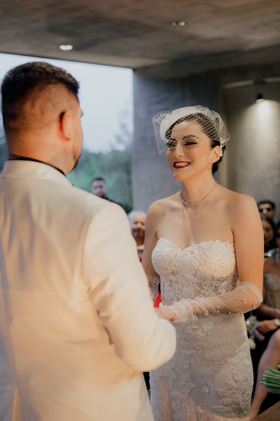 A couple exchanges vows during an intimate indoor wedding ceremony.