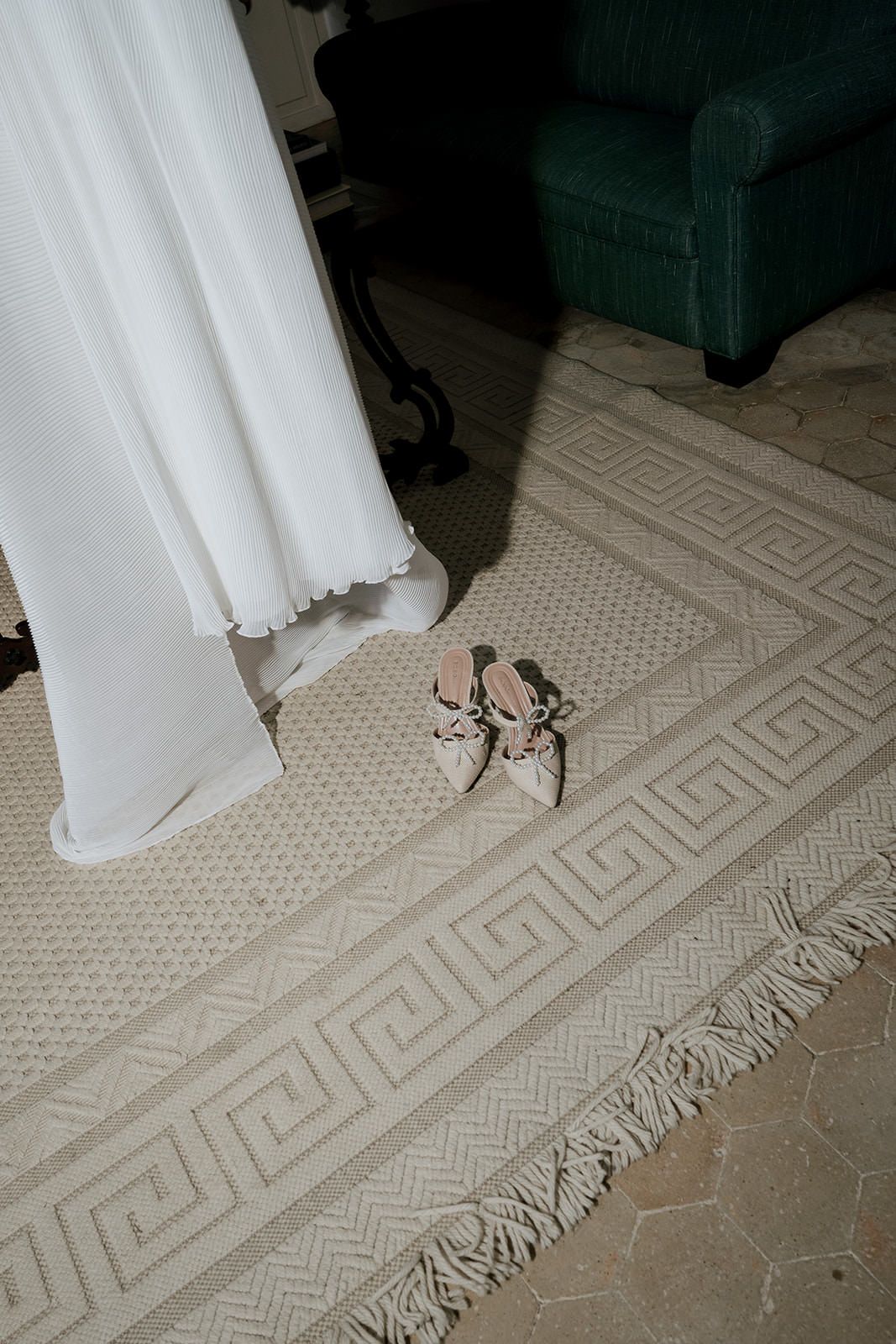 A series of white wedding dress hem and shoes shown against a patterned beige carpet in different poses.