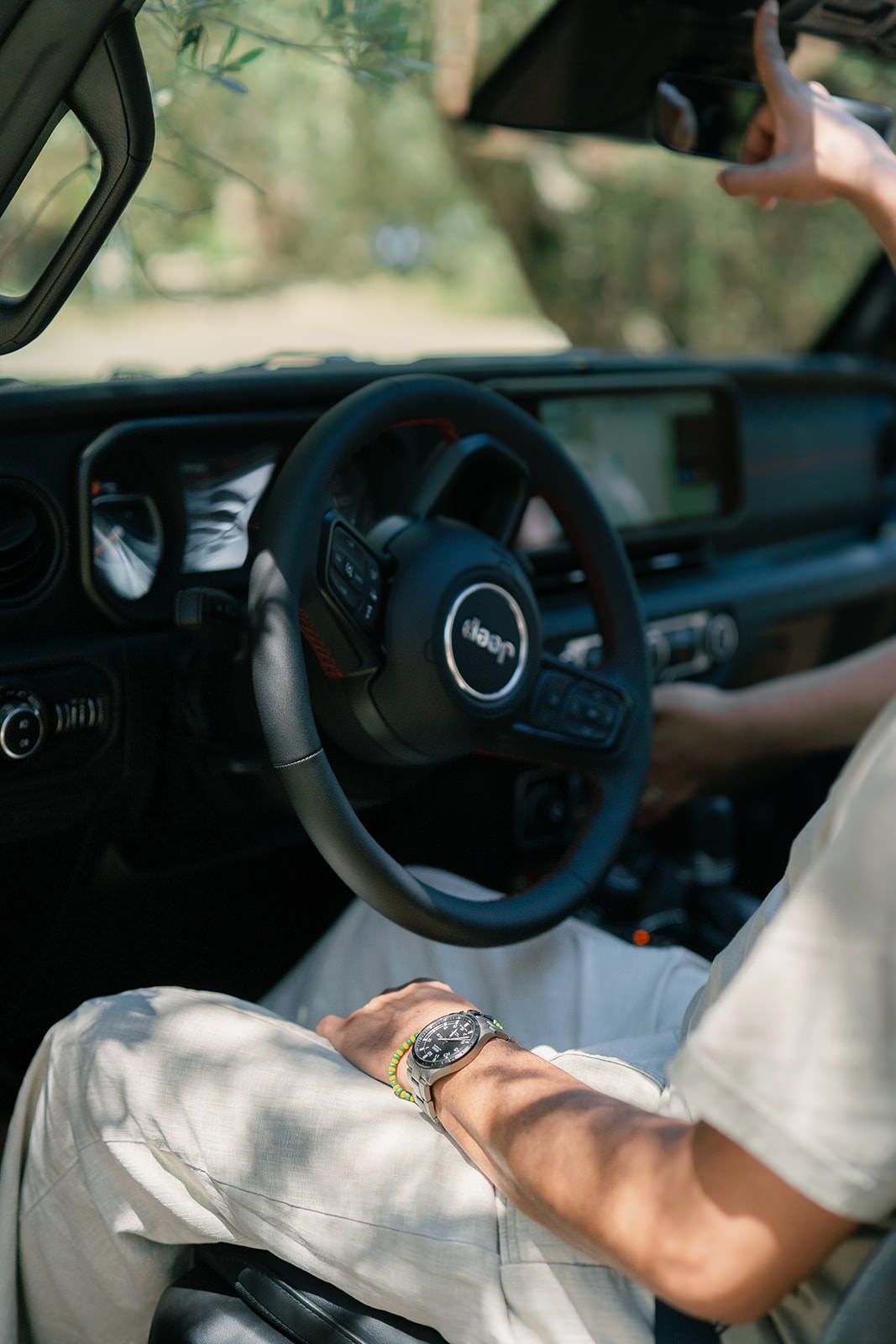 Interior view of a luxury car dashboard and steering wheel with sunlight streaming in.