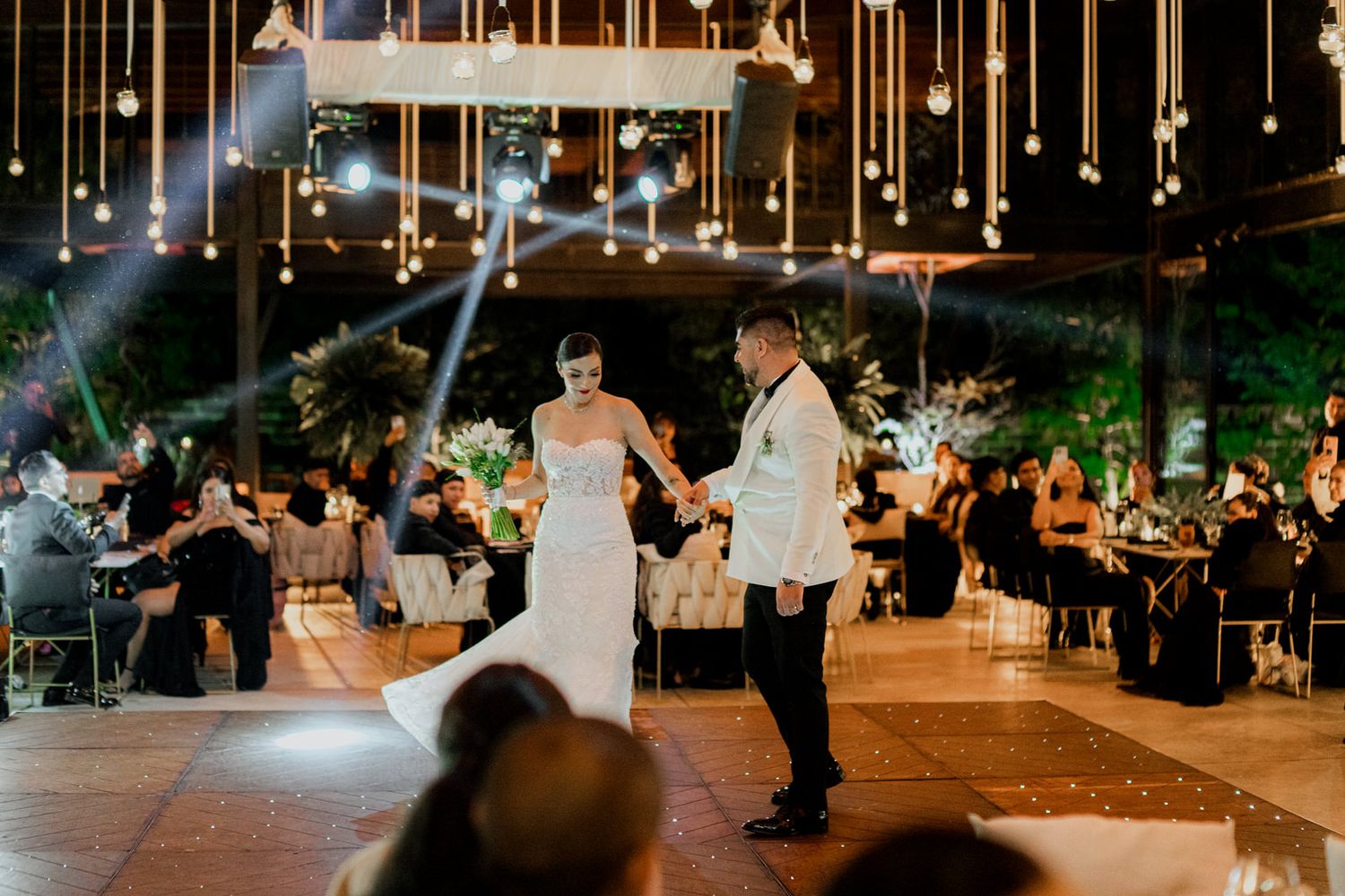 Elegant wedding reception venue with hanging lights and romantic ambiance.