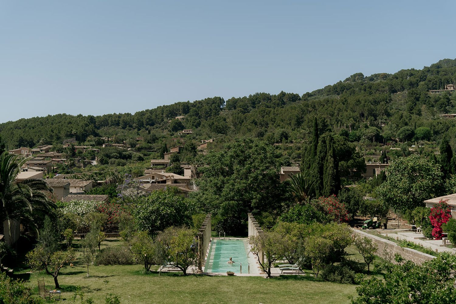 Scenic valley view with olive groves and traditional buildings dotting the countryside.