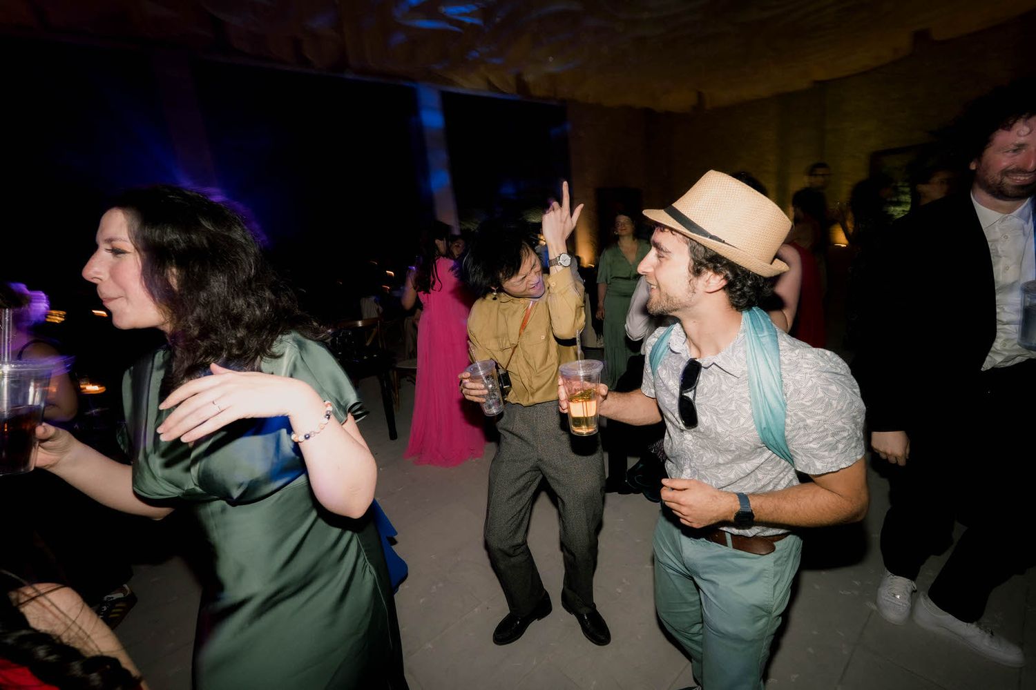 Dance party scene with people dancing in a dimly lit space.