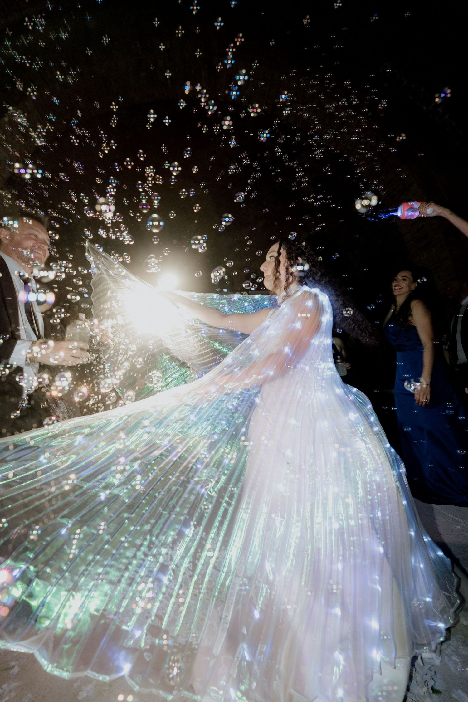 Stunning illuminated wedding dress glowing with fiber optic lights on a dark dance floor.