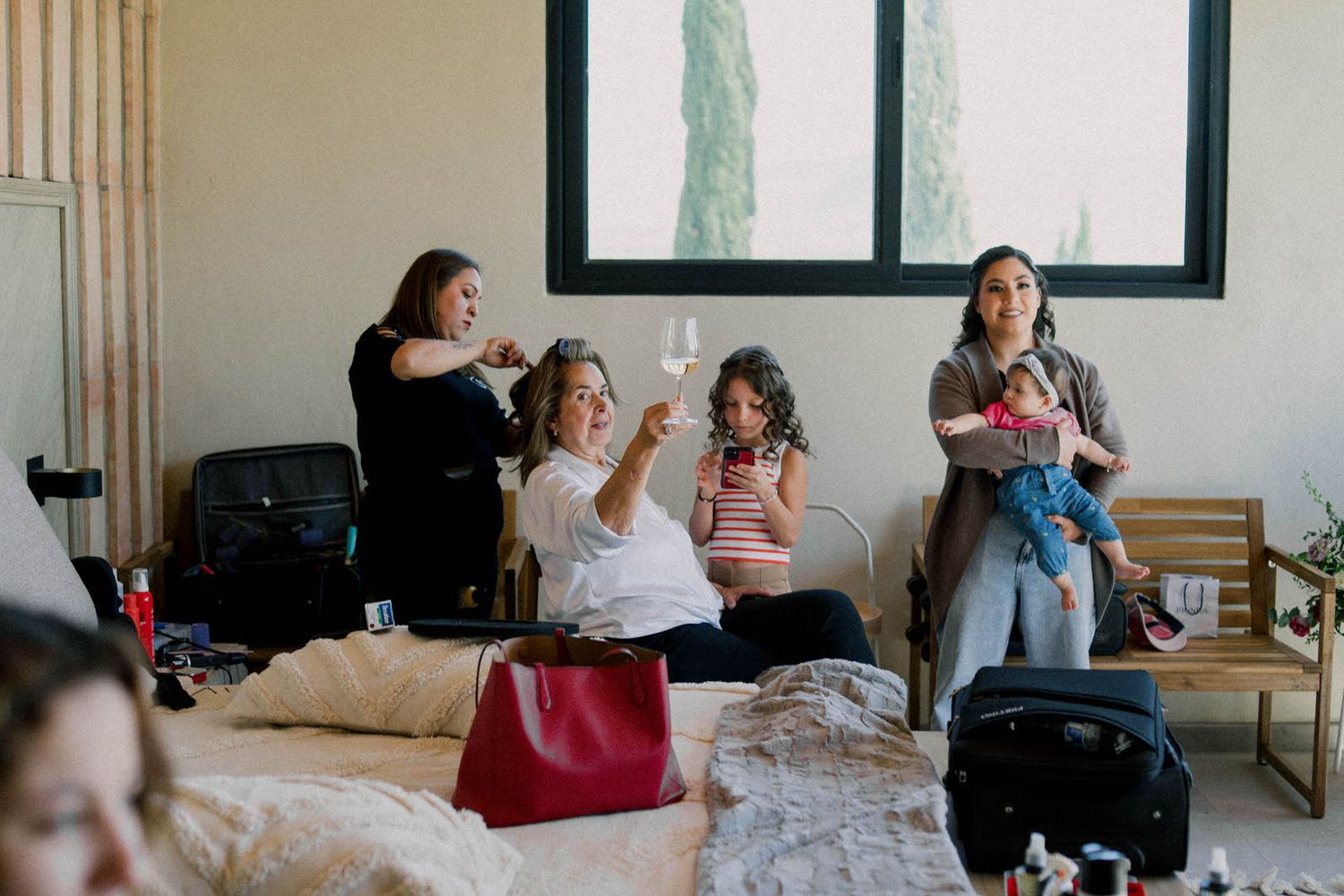 Group gathering in casual setting with luggage and personal items visible.