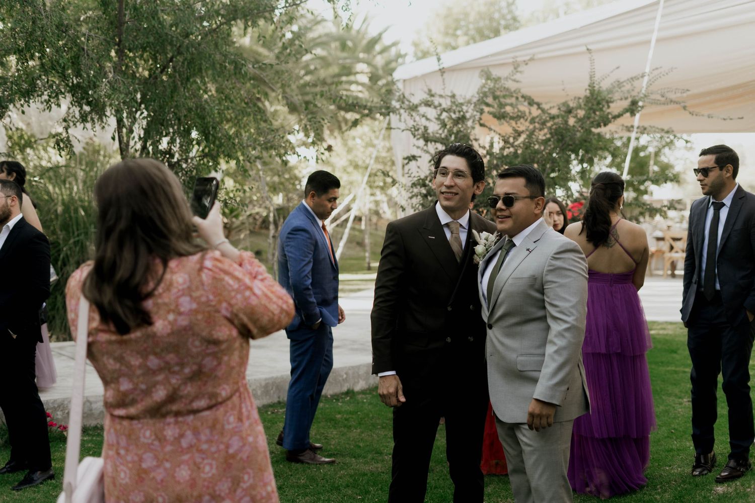 Wedding guests socializing on a lawn during an outdoor reception.