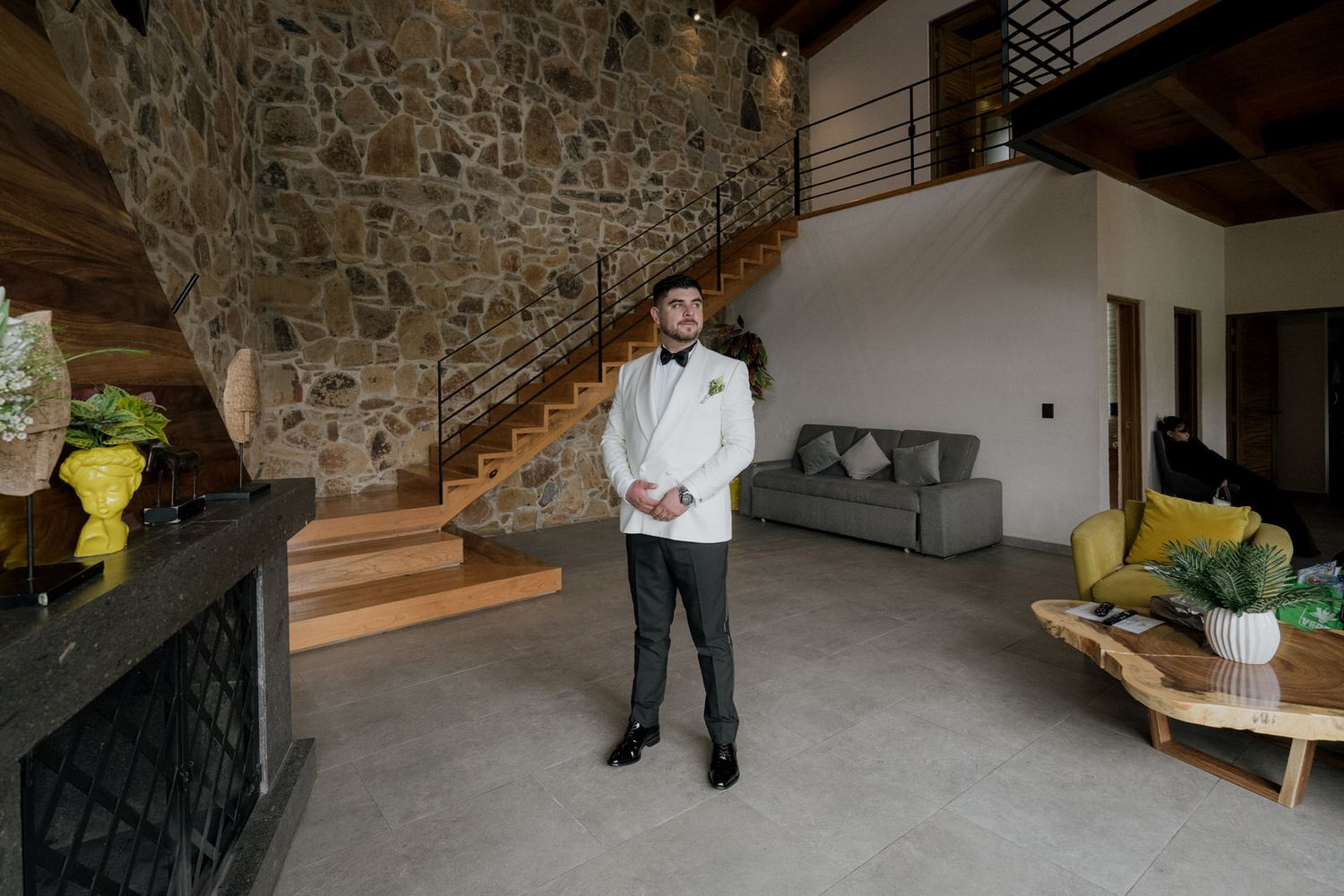Modern interior space featuring stone walls, wooden stairs, and contemporary furnishings.