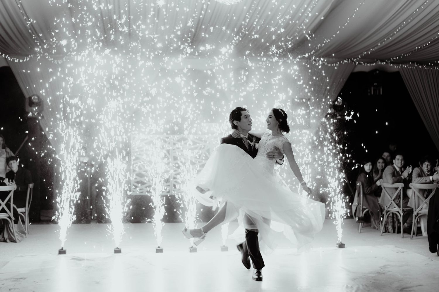Indoor sparkler fountains create magical effects during a wedding reception dance performance.